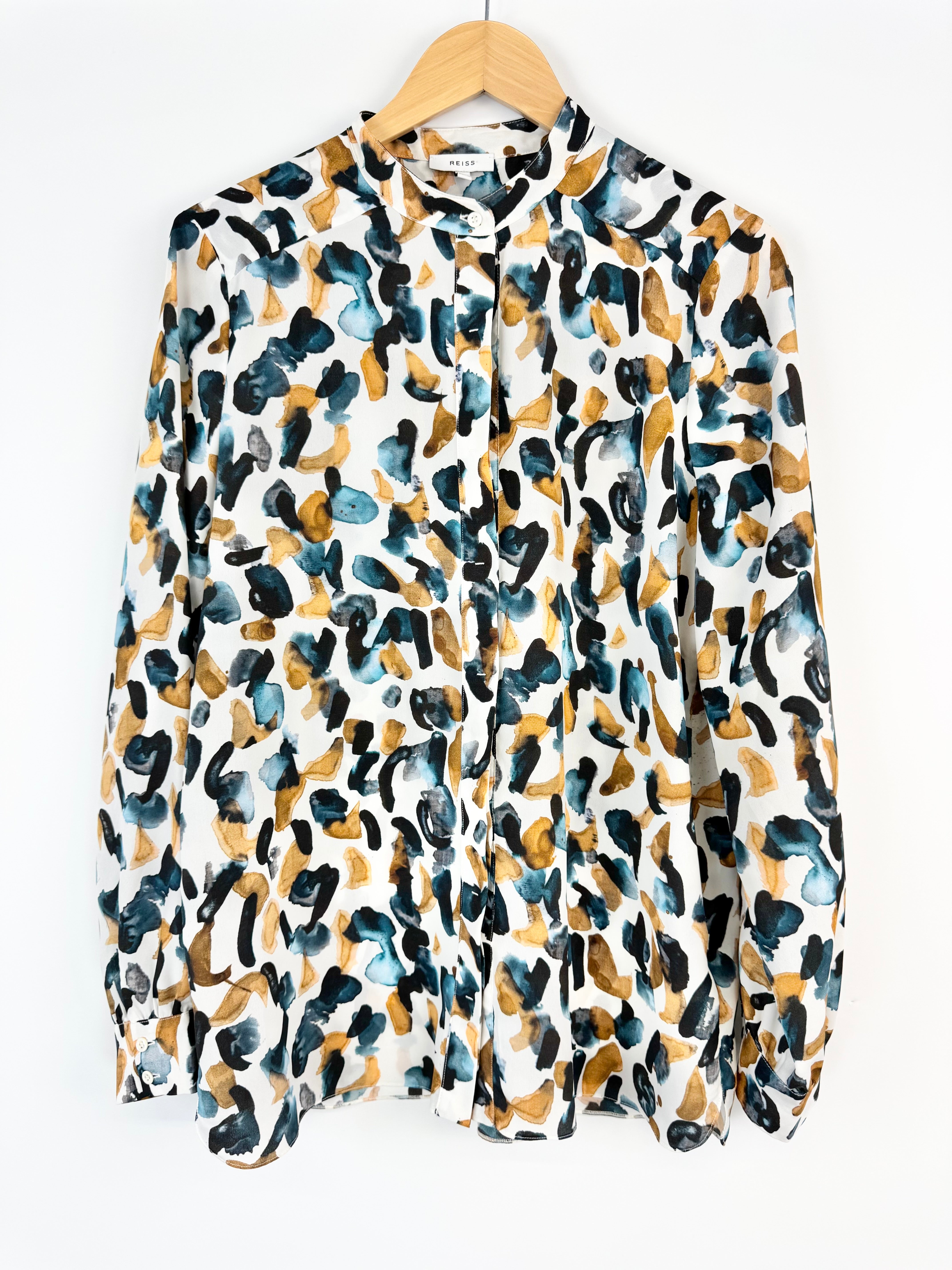 Patterned shirt on a hanger against a white background