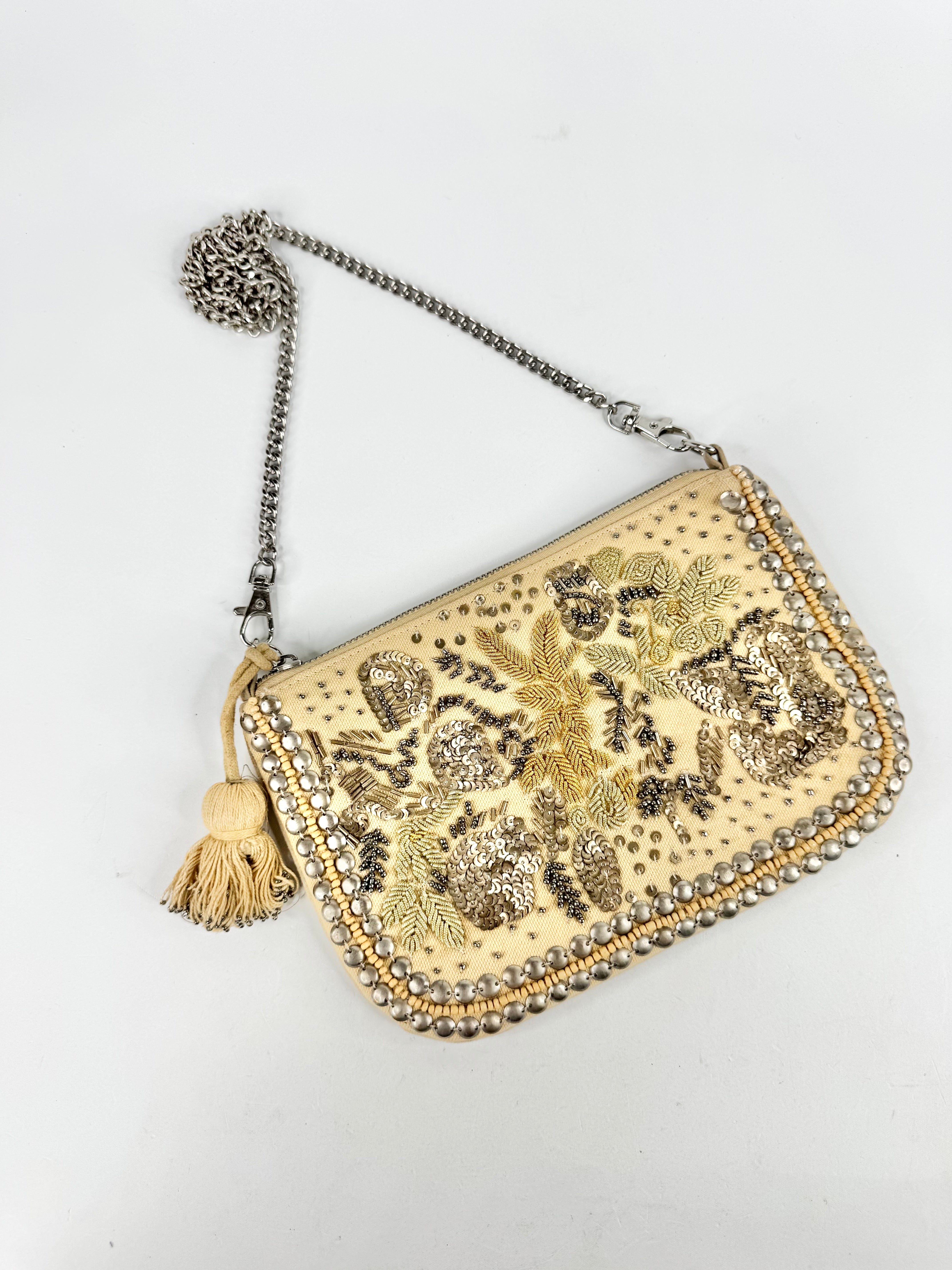 Gold embellished clutch bag with chain strap on a white background