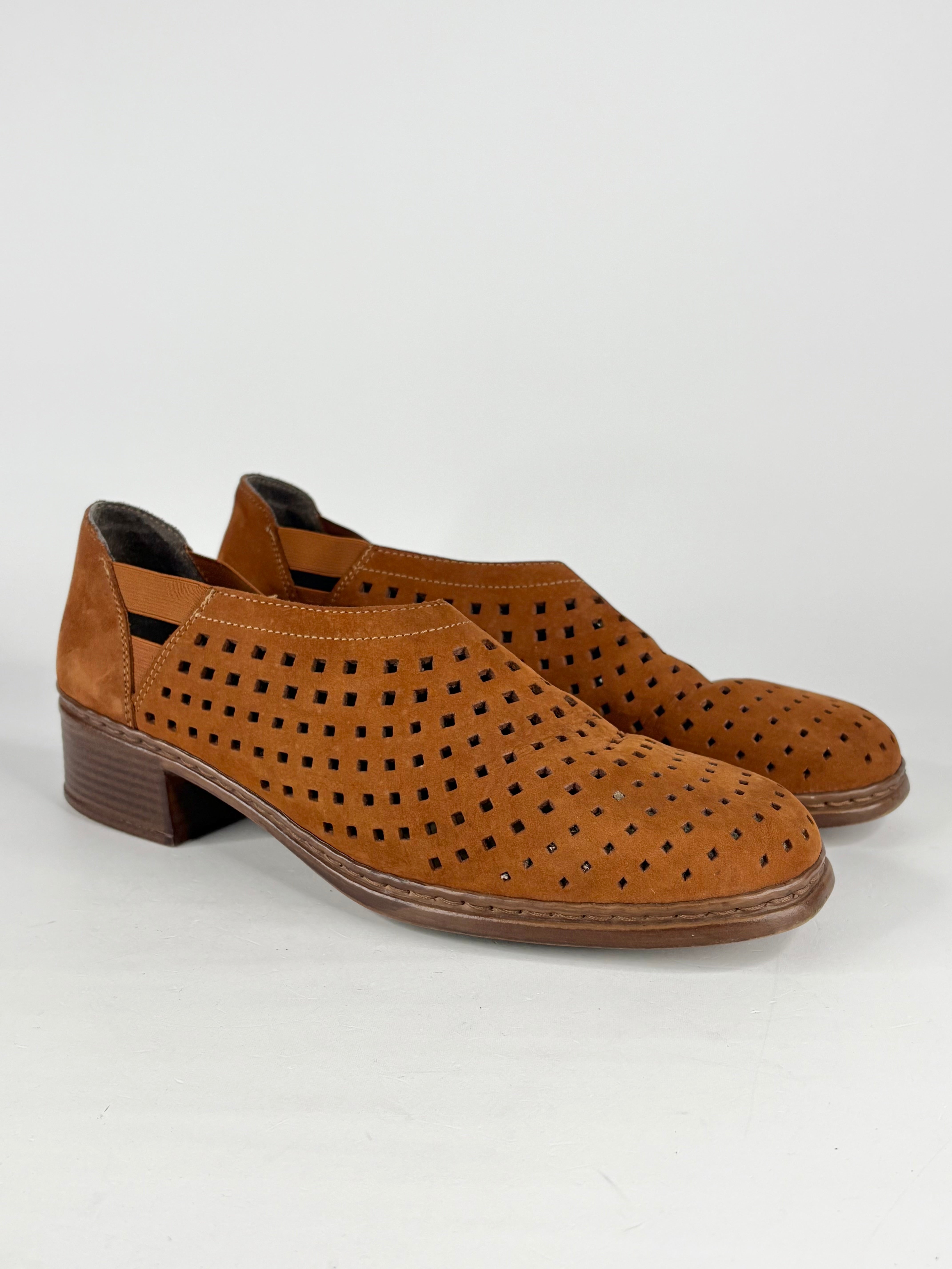 Pair of brown suede shoes with perforated design on a white background