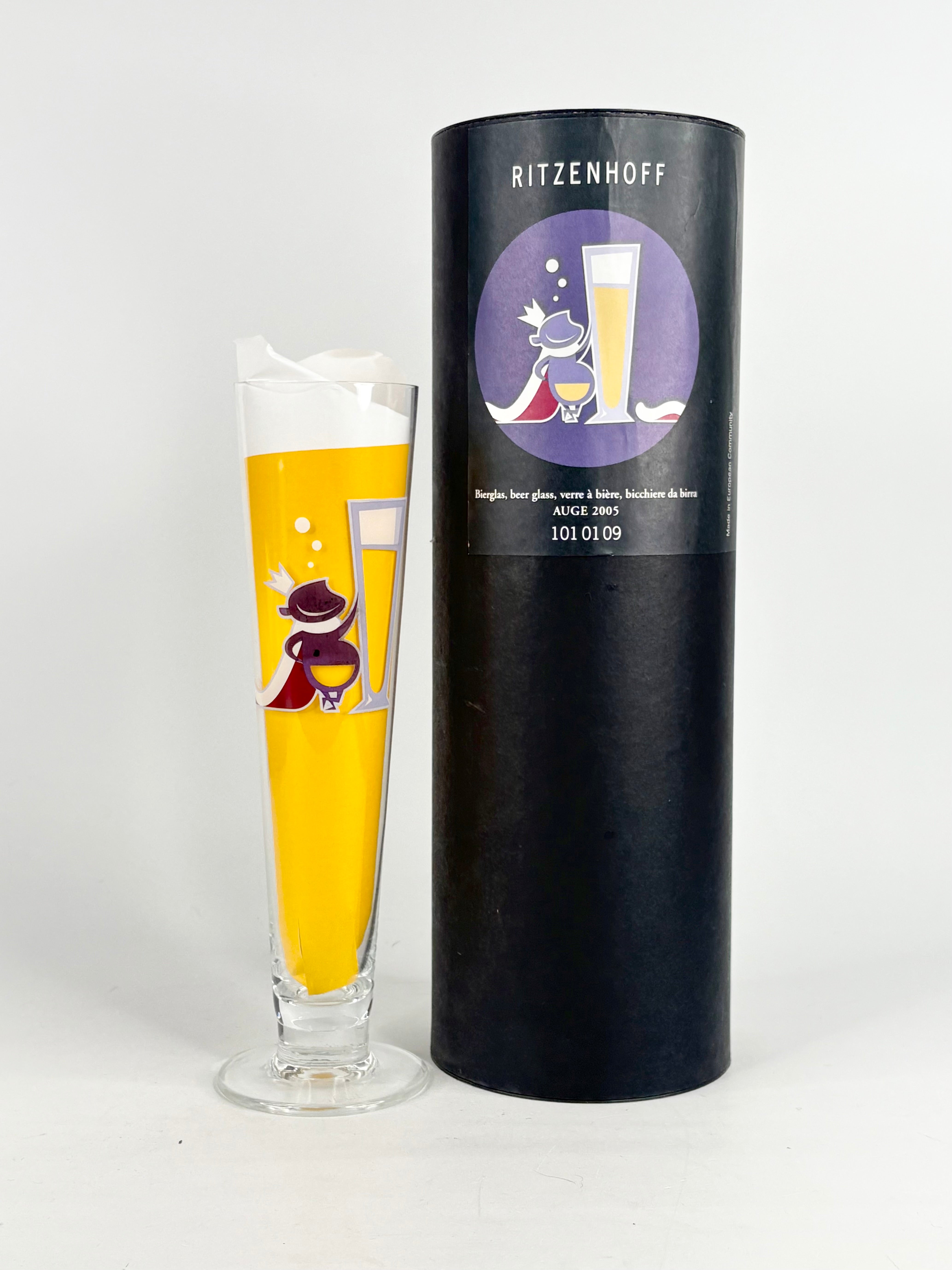 Glass with yellow design and black cylindrical packaging labeled 'Ritzenhoff' on a white background