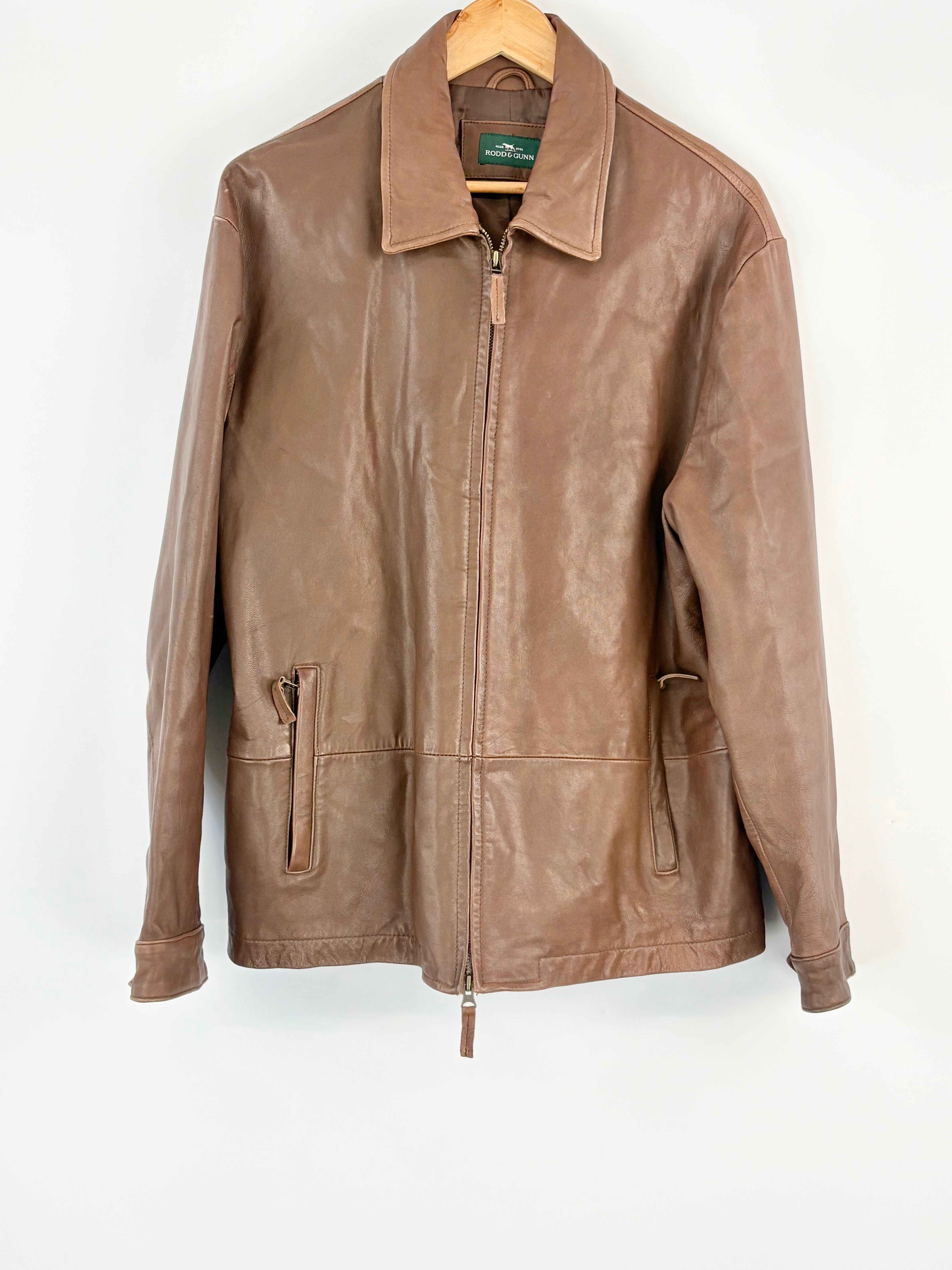 Brown leather jacket on a hanger against a white background