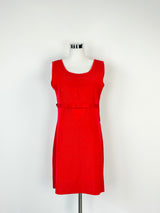 A crimson red, sleeveless knit wear dress with a ribbon at the waist and bow at the center, displayed on a mannequin.