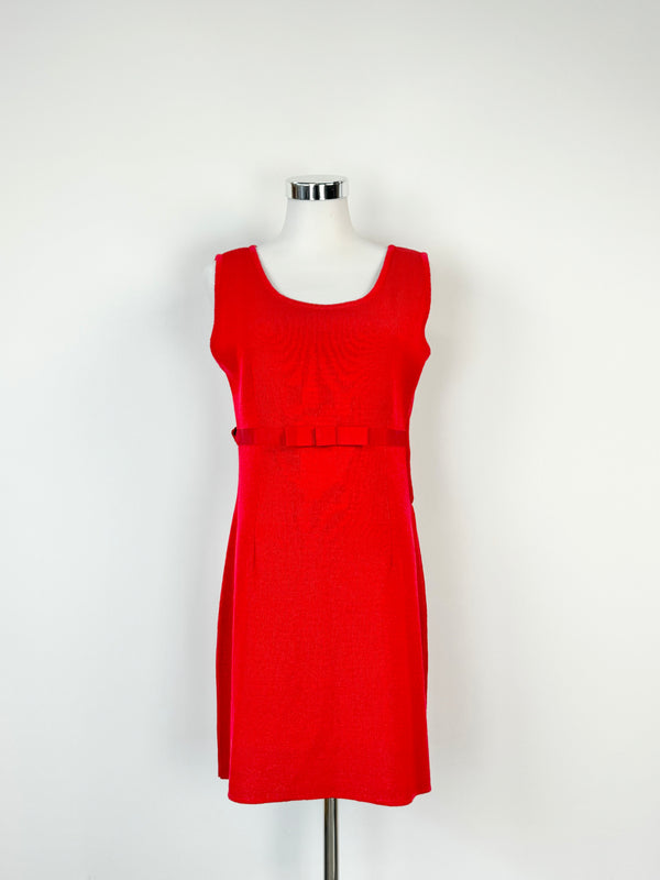 A crimson red, sleeveless knit wear dress with a ribbon at the waist and bow at the center, displayed on a mannequin.