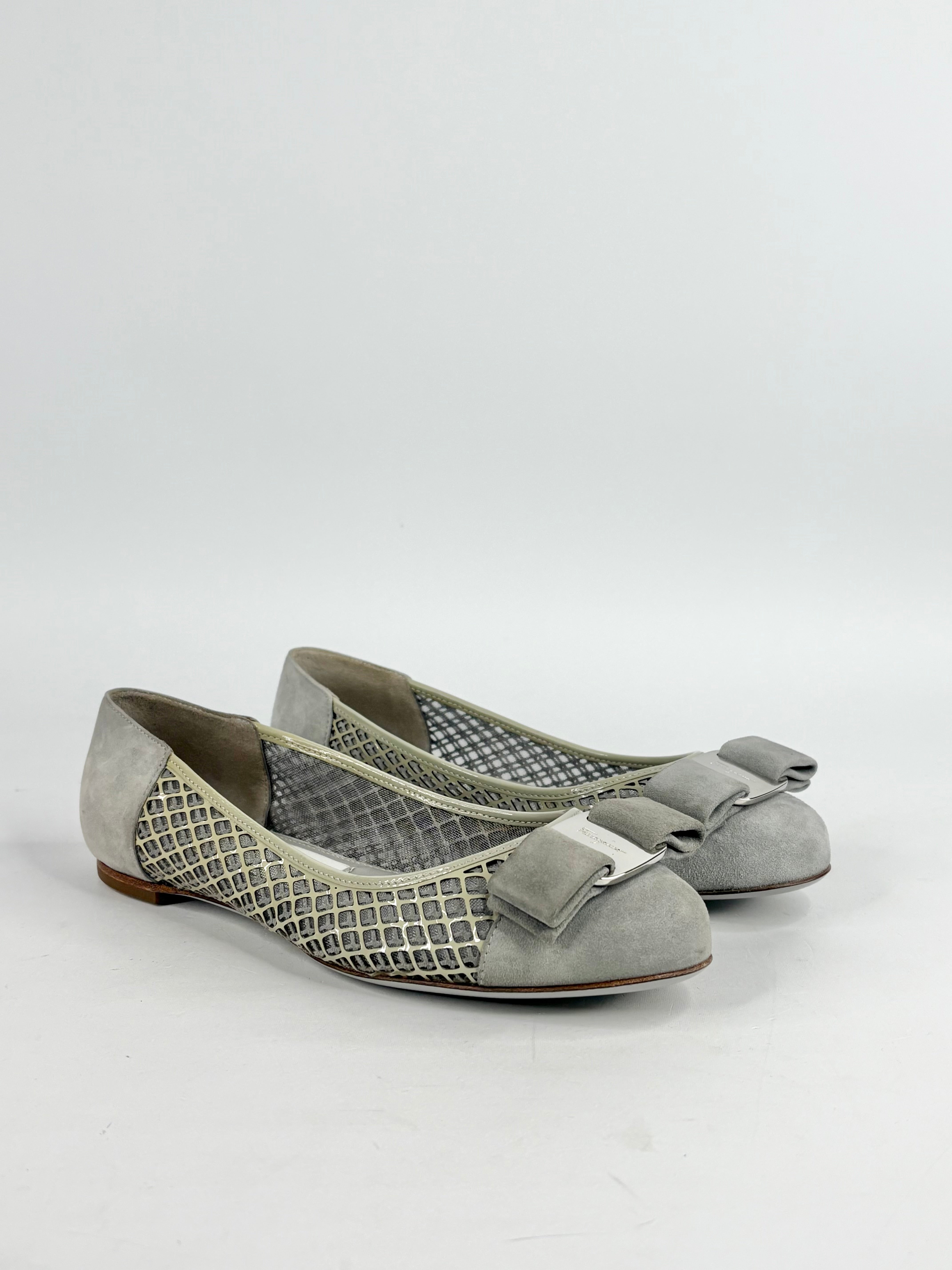 Pair of gray flat shoes with bow detail on a white background