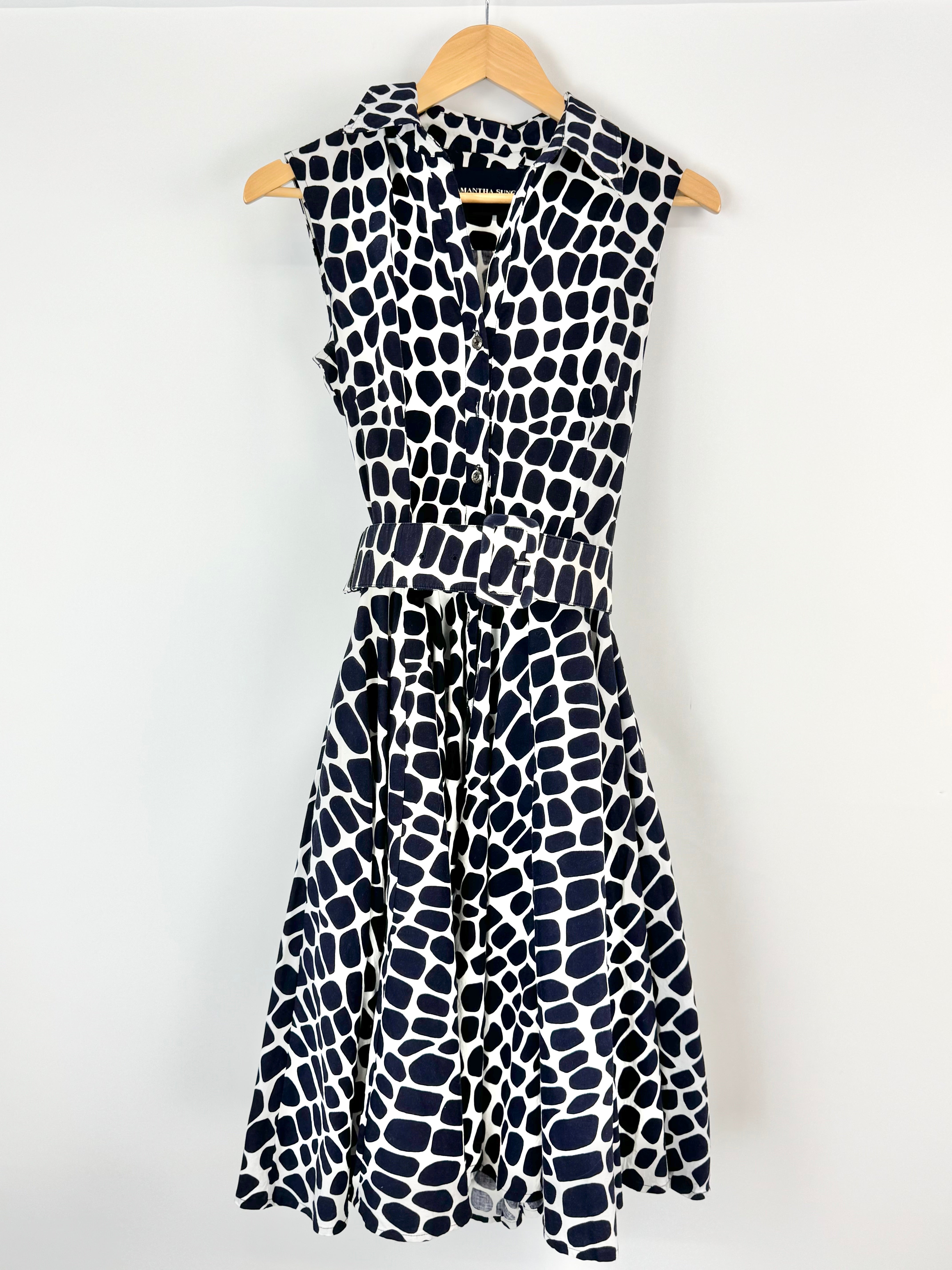 Black and white patterned dress on a hanger against a white background