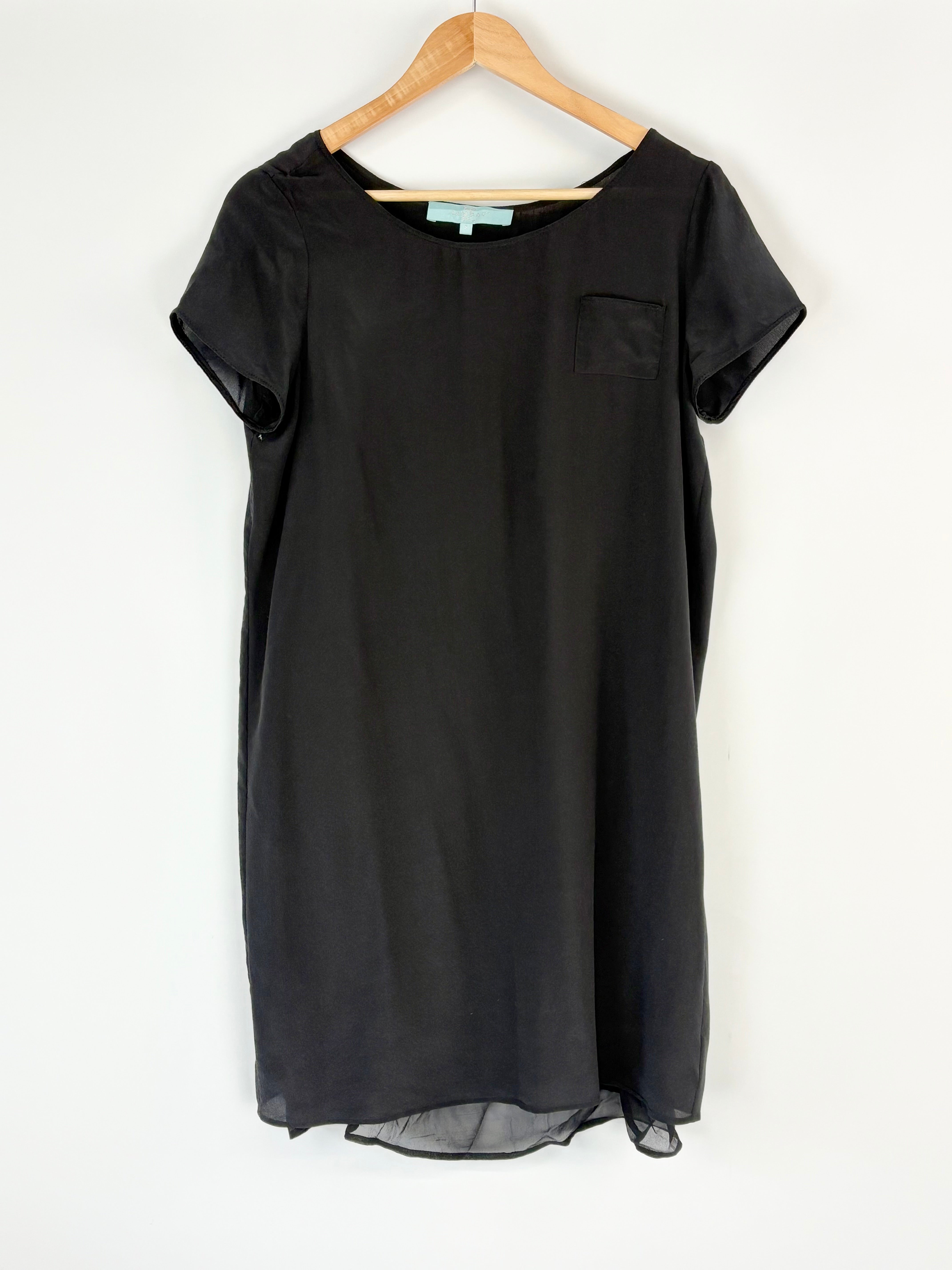 Black dress on a hanger against a white background