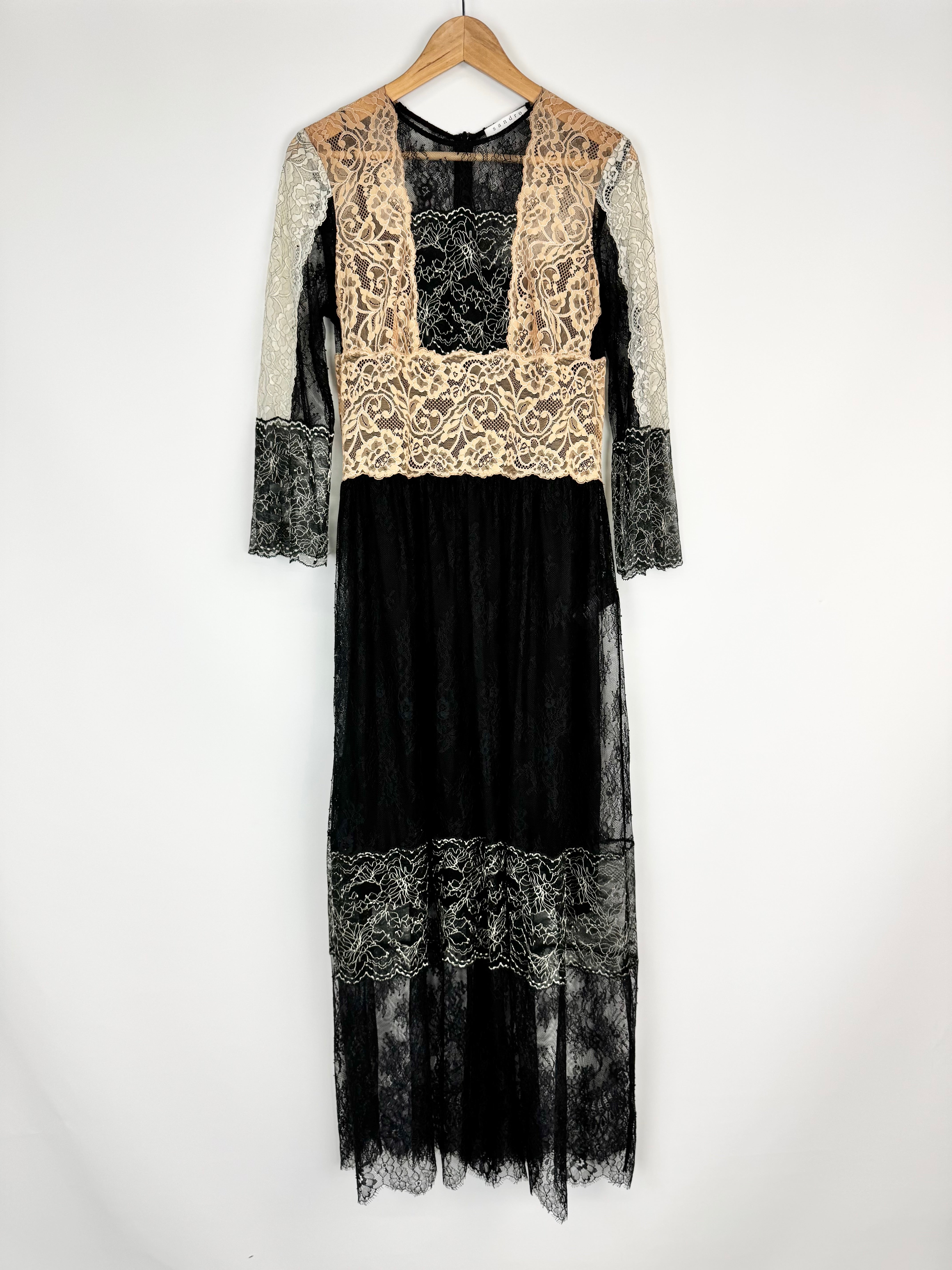 Black and white lace dress on a hanger against a white background