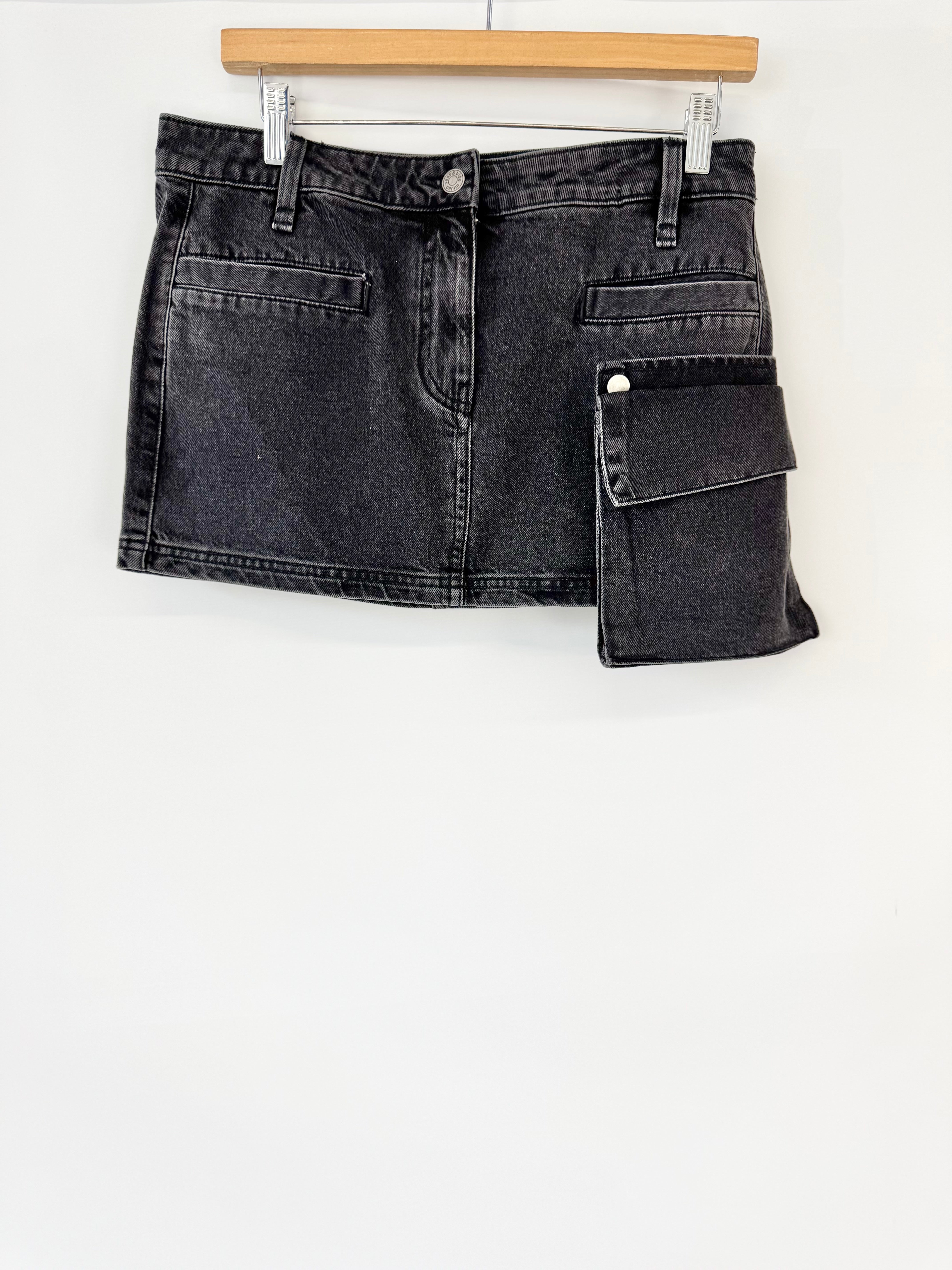 Black denim mini skirt on a hanger against a white background