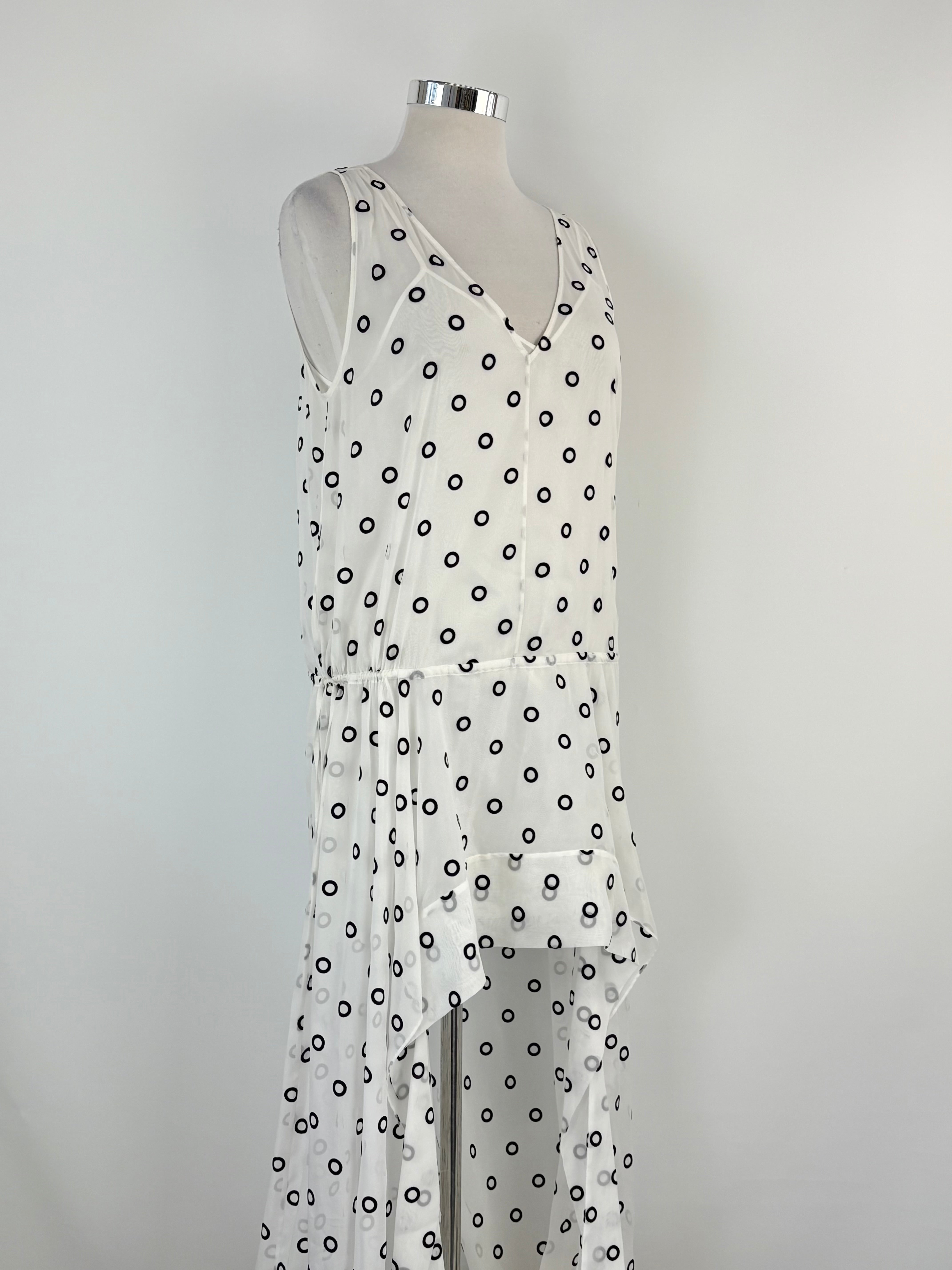White dress with black polka dots on a mannequin against a gray background