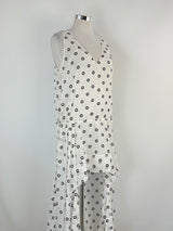 White dress with black polka dots on a mannequin against a gray background
