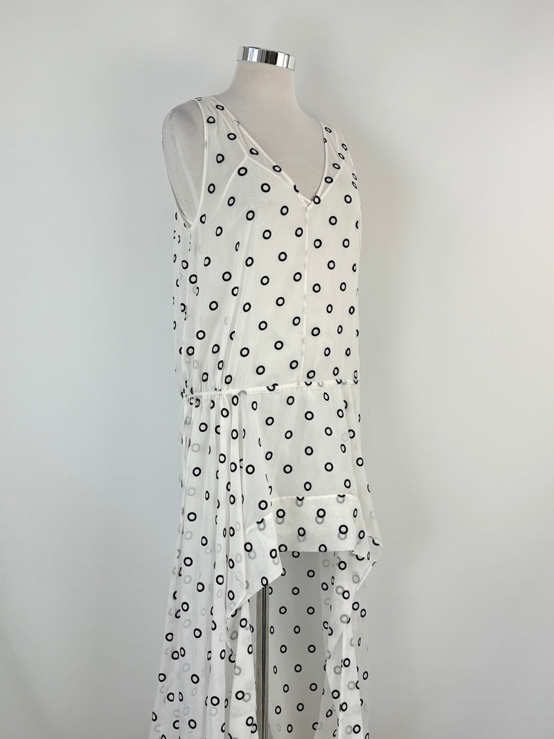 White dress with black polka dots on a mannequin against a gray background