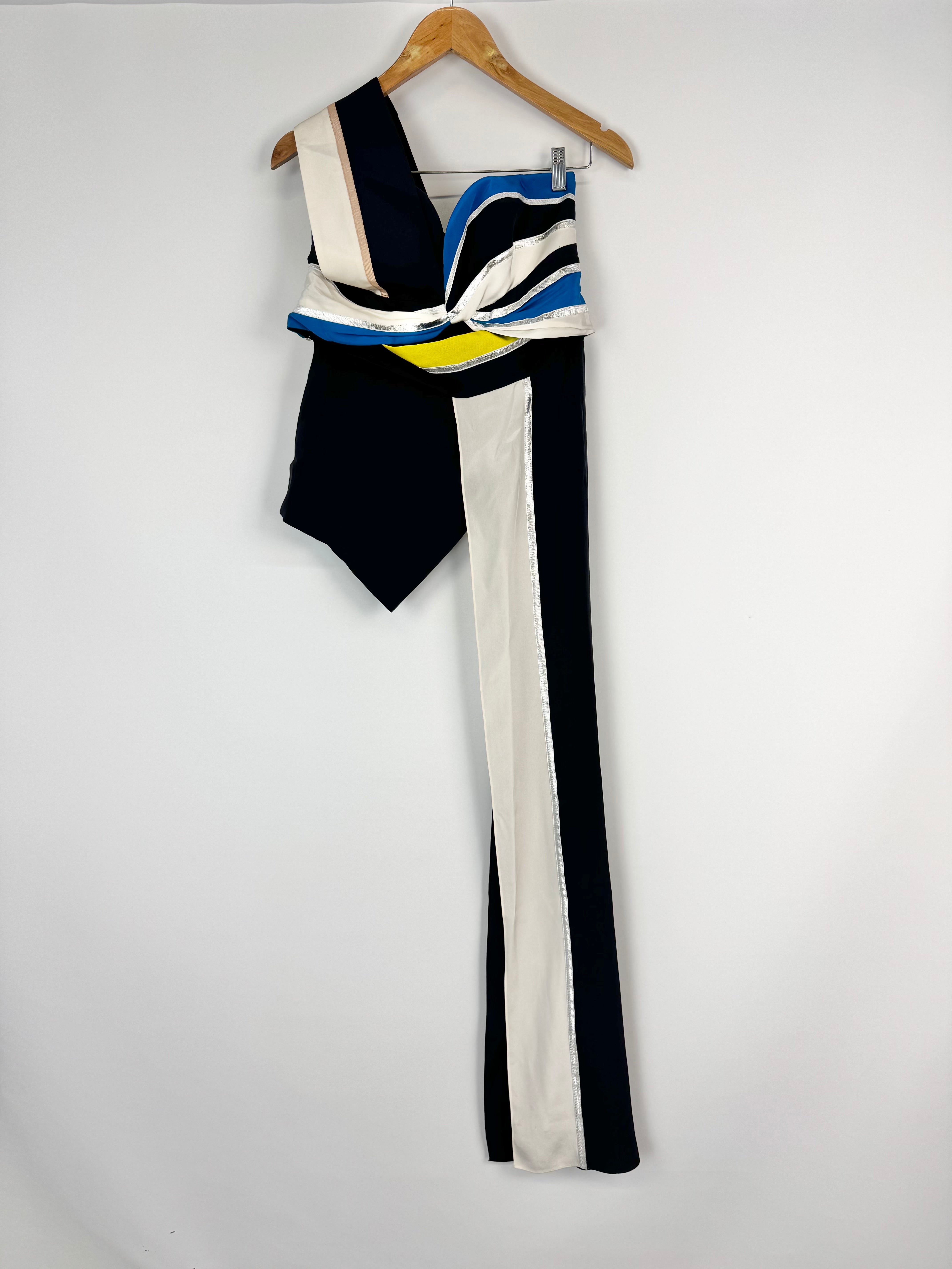Colorful dress with geometric pattern on a hanger against a white background