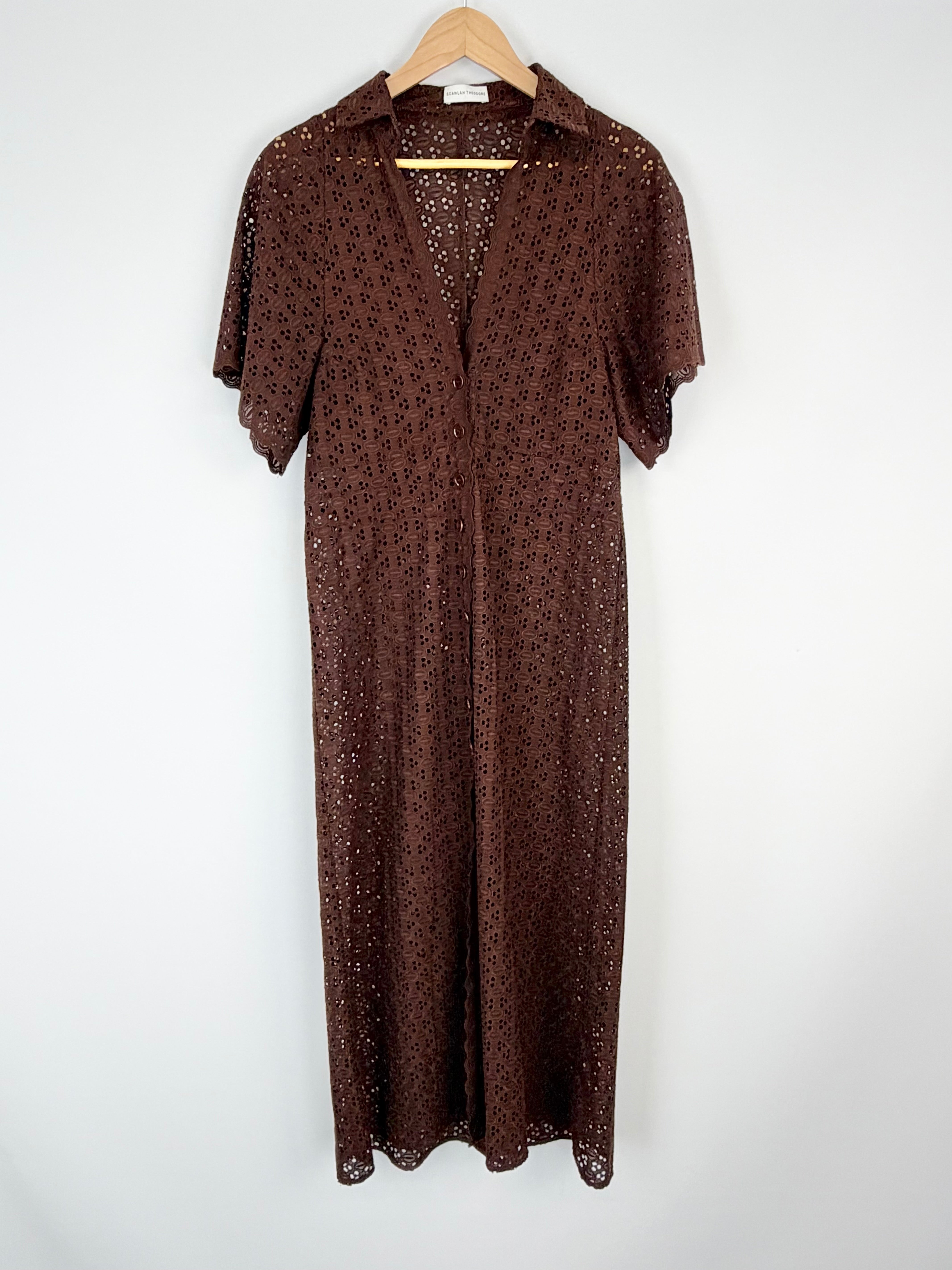 Brown patterned dress on a hanger against a white background