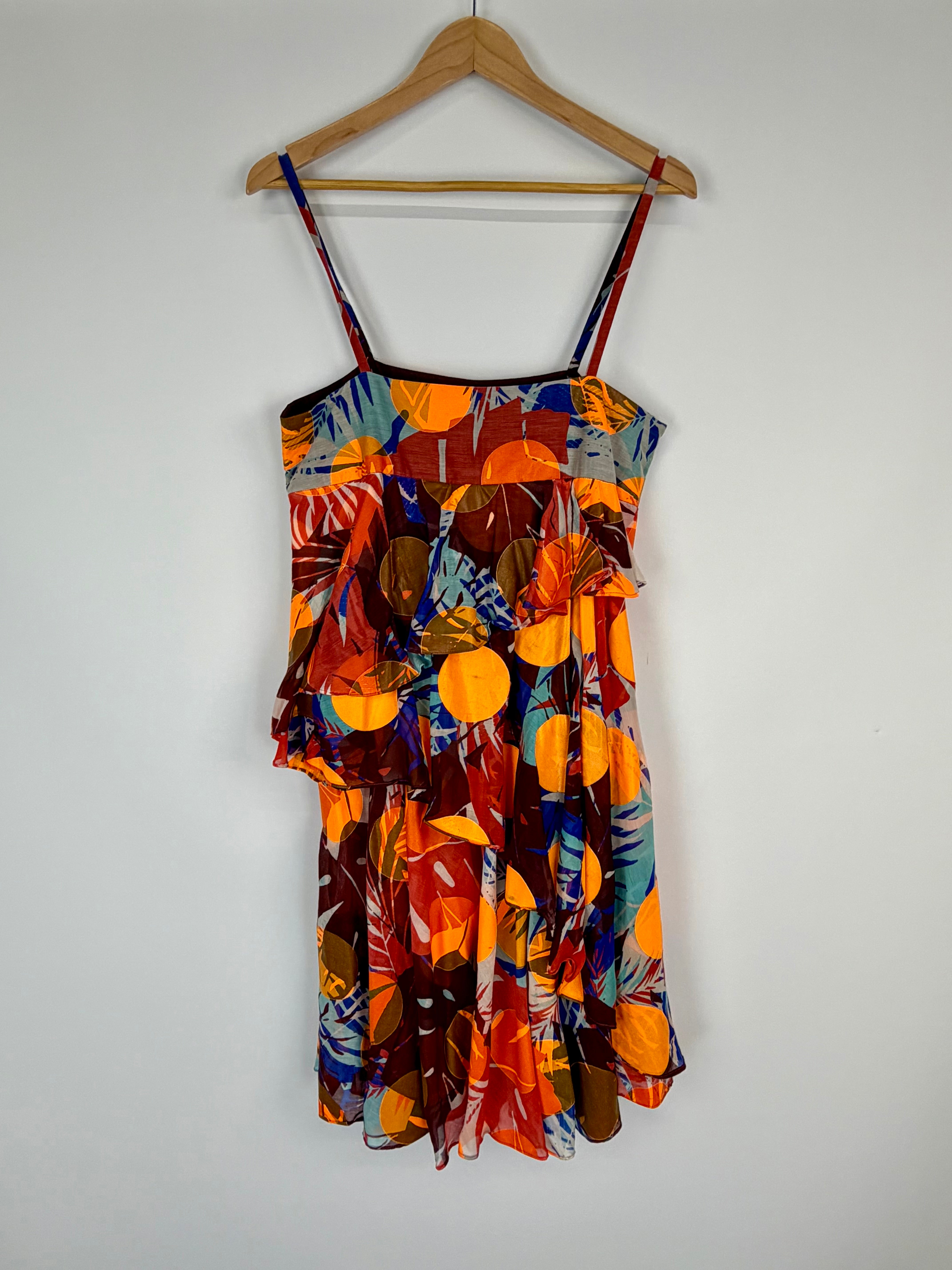 Colorful dress with a pattern on a hanger against a white background