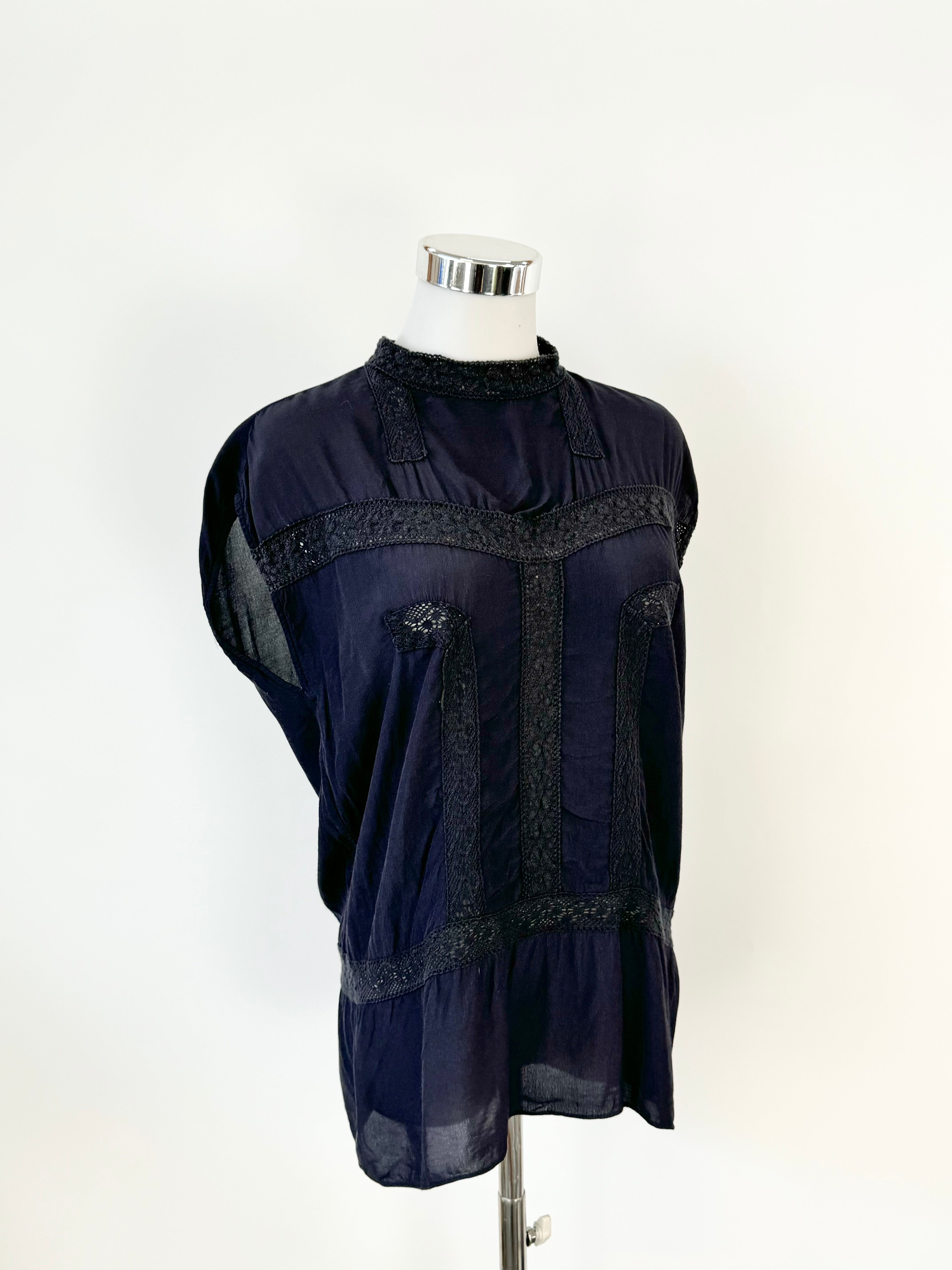 A navy blue viscose fabric top with lace detailing displayed on a mannequin.