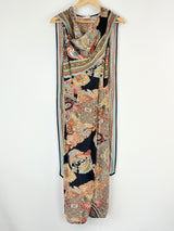 Long, patterned dress draped over a hanger on a white background