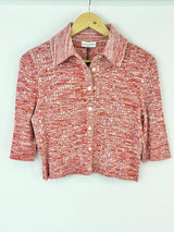 Red and white patterned shirt on a hanger against a white background