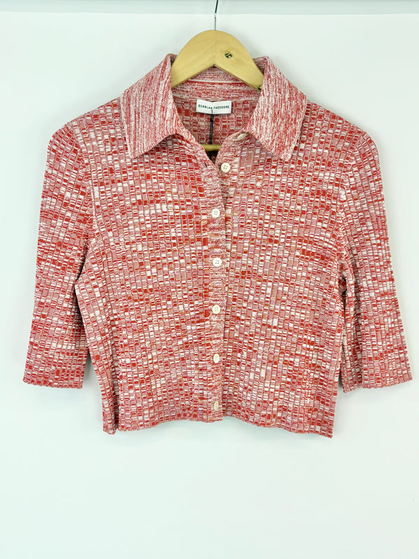 Red and white patterned shirt on a hanger against a white background
