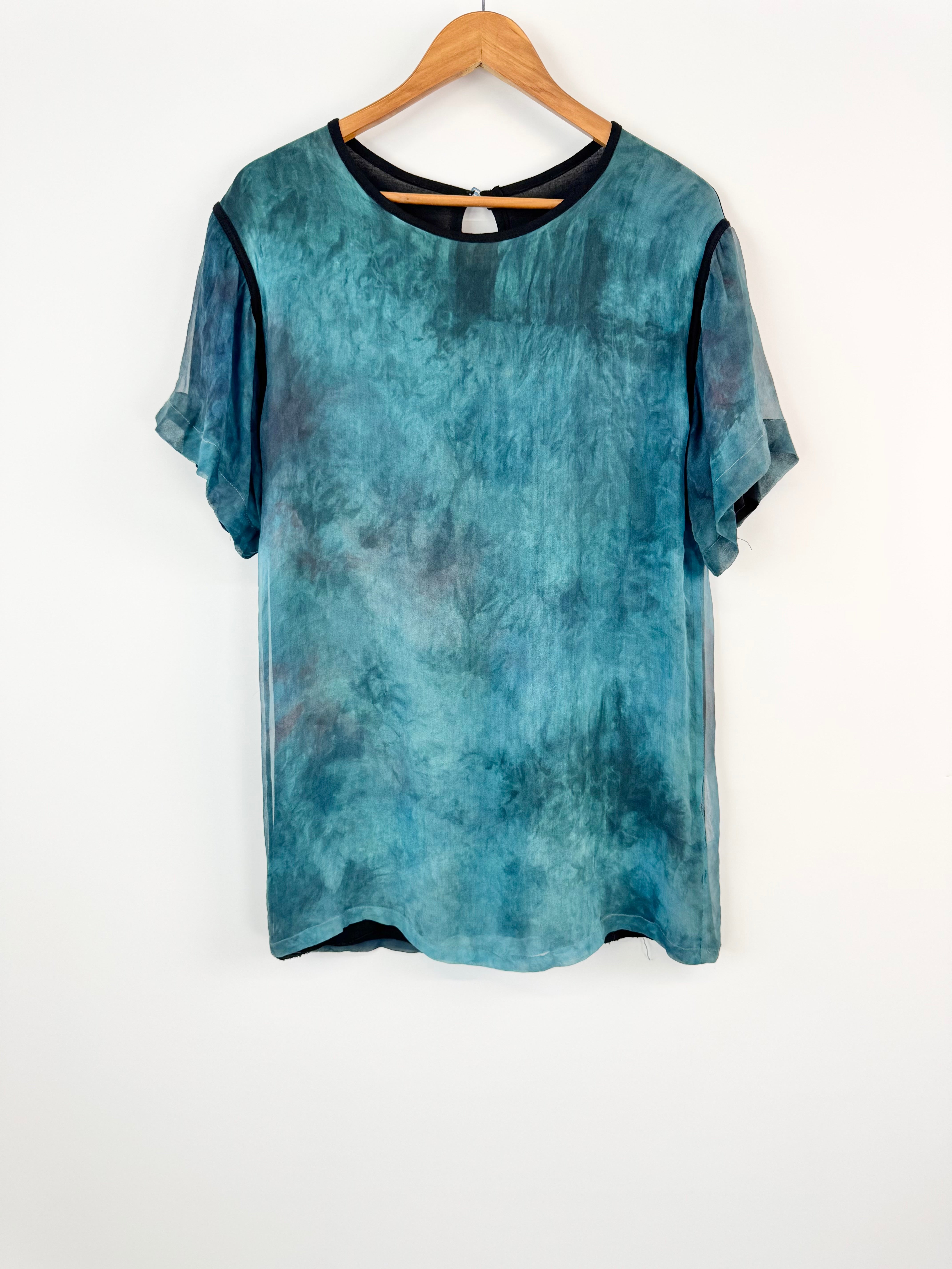 Blue tie-dye t-shirt on a hanger against a white background