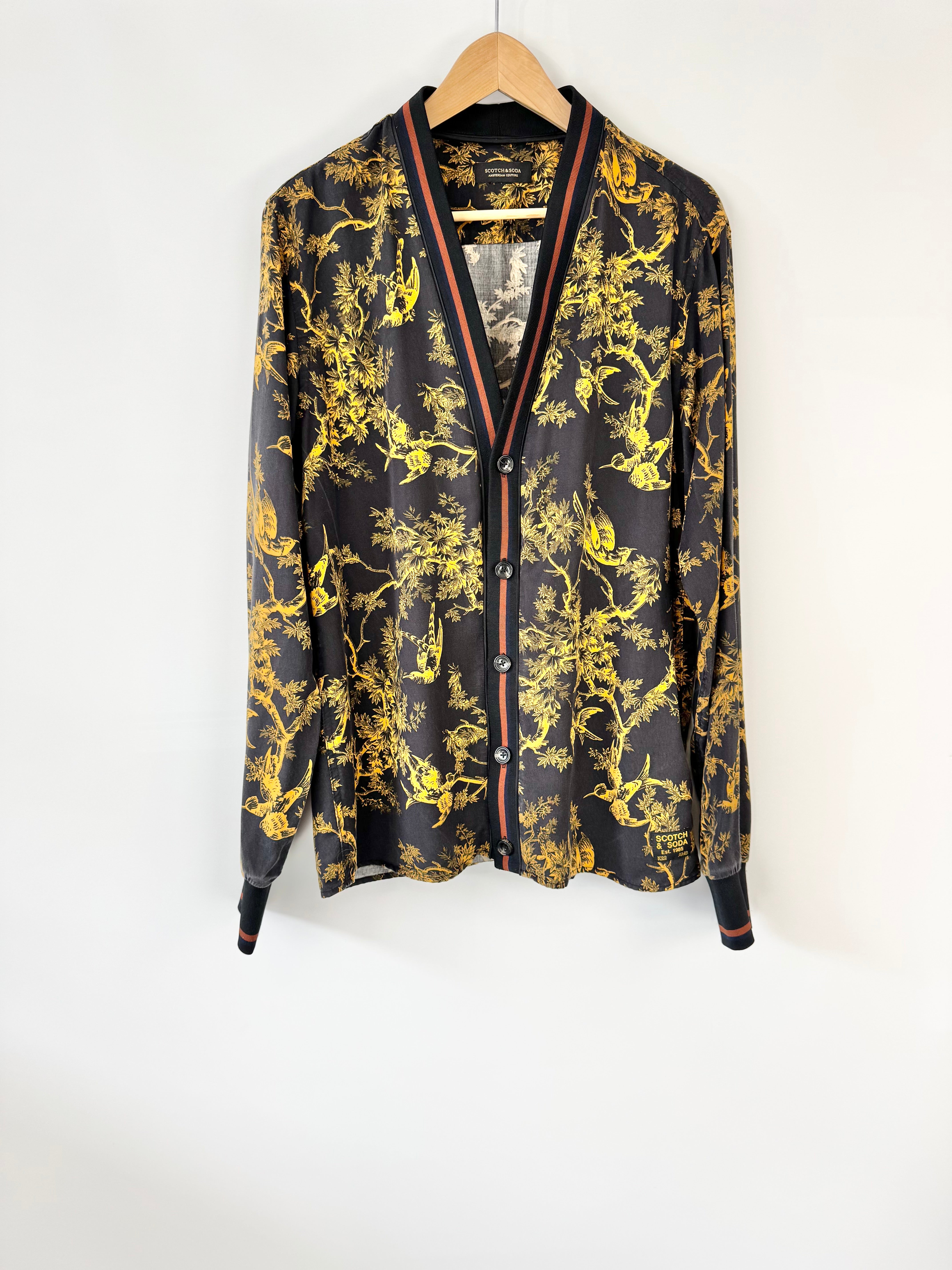 Black shirt with gold floral pattern on a white background