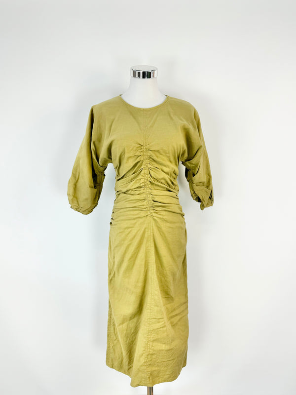 A lichen green, puff sleeve ruched mini dress on a mannequin against a white background.