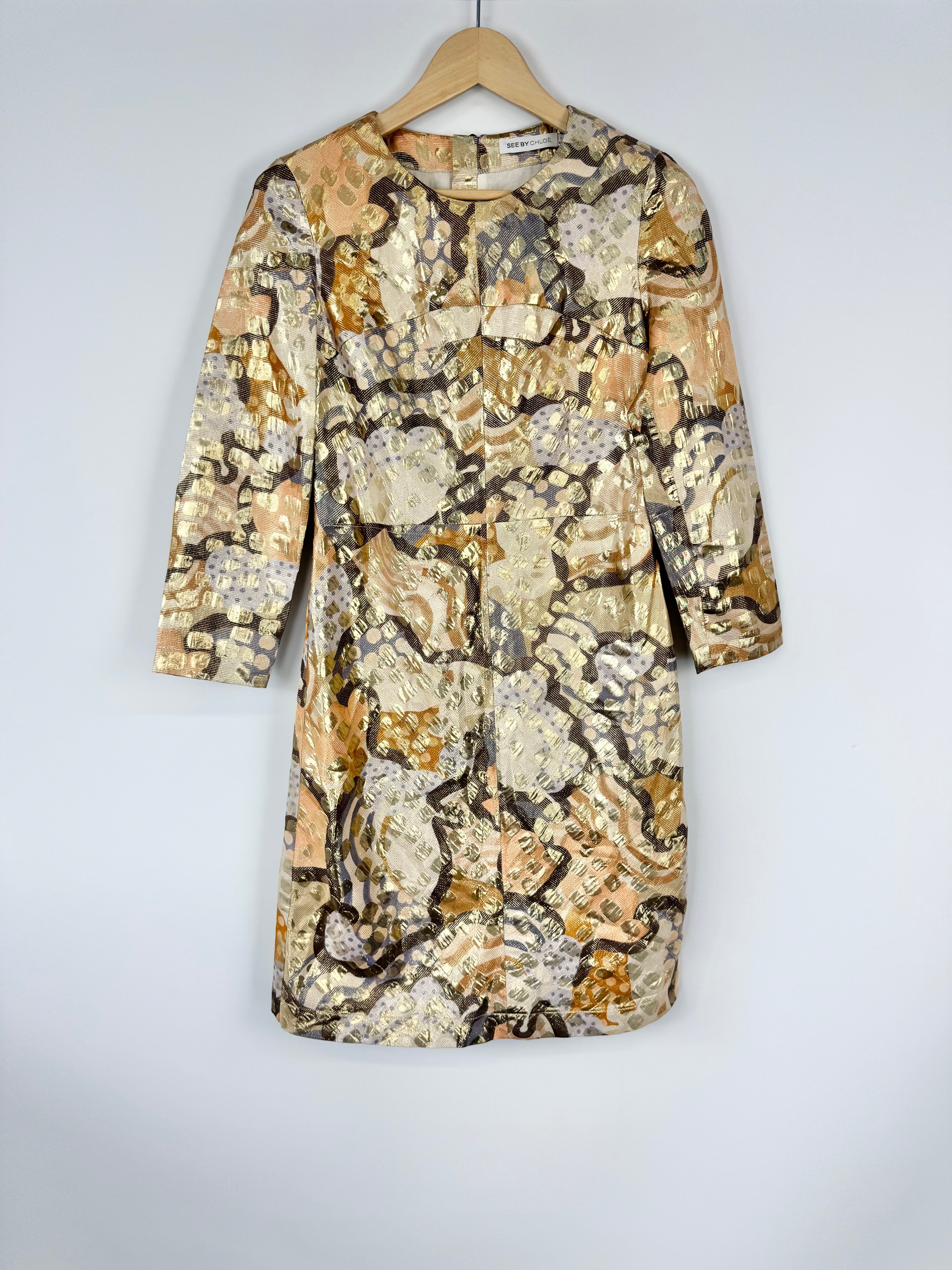 Patterned dress on a hanger against a white background