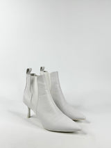 Pair of white ankle boots on a light gray background