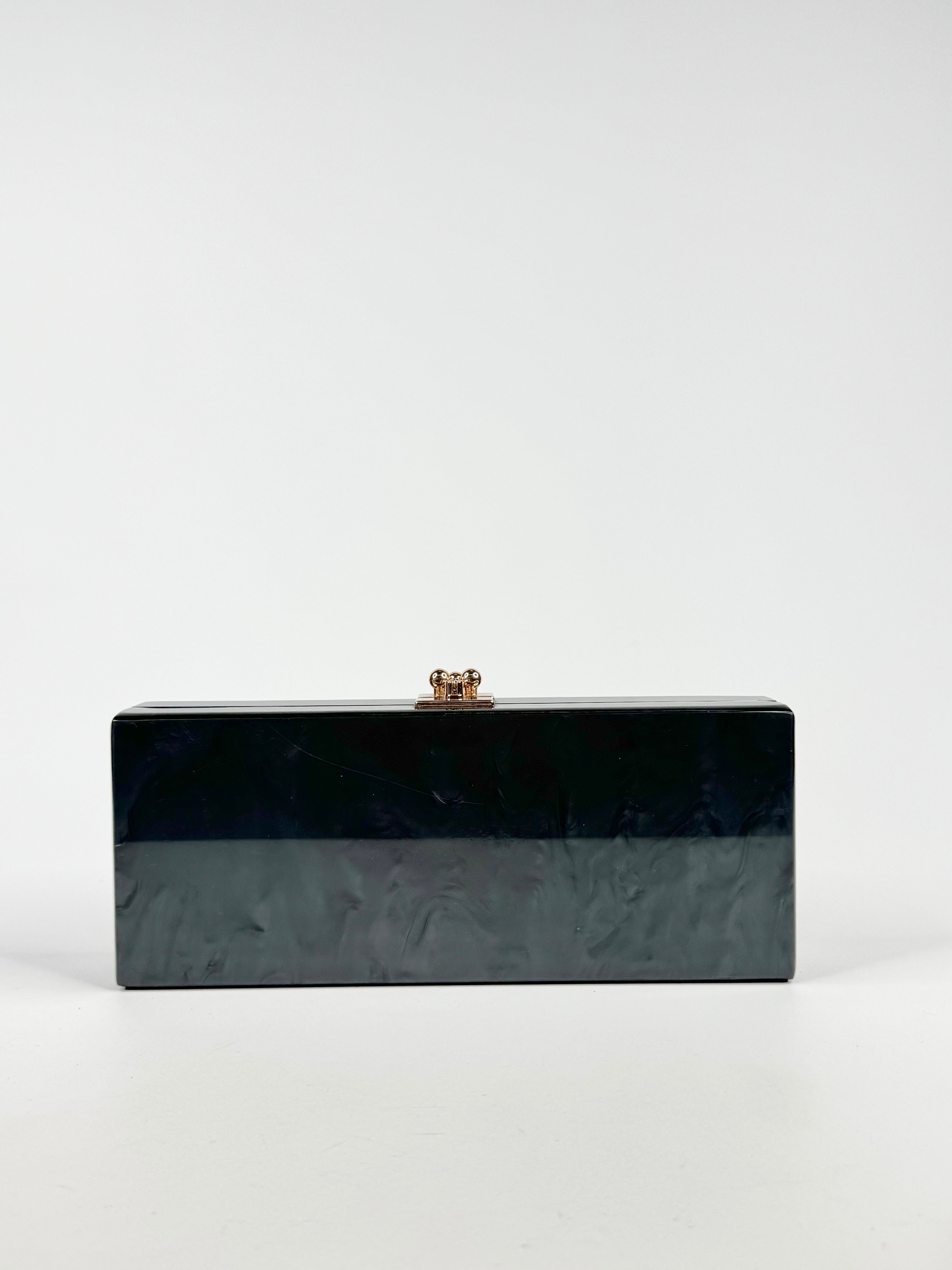 Black rectangular clutch bag with a gold clasp on a white background