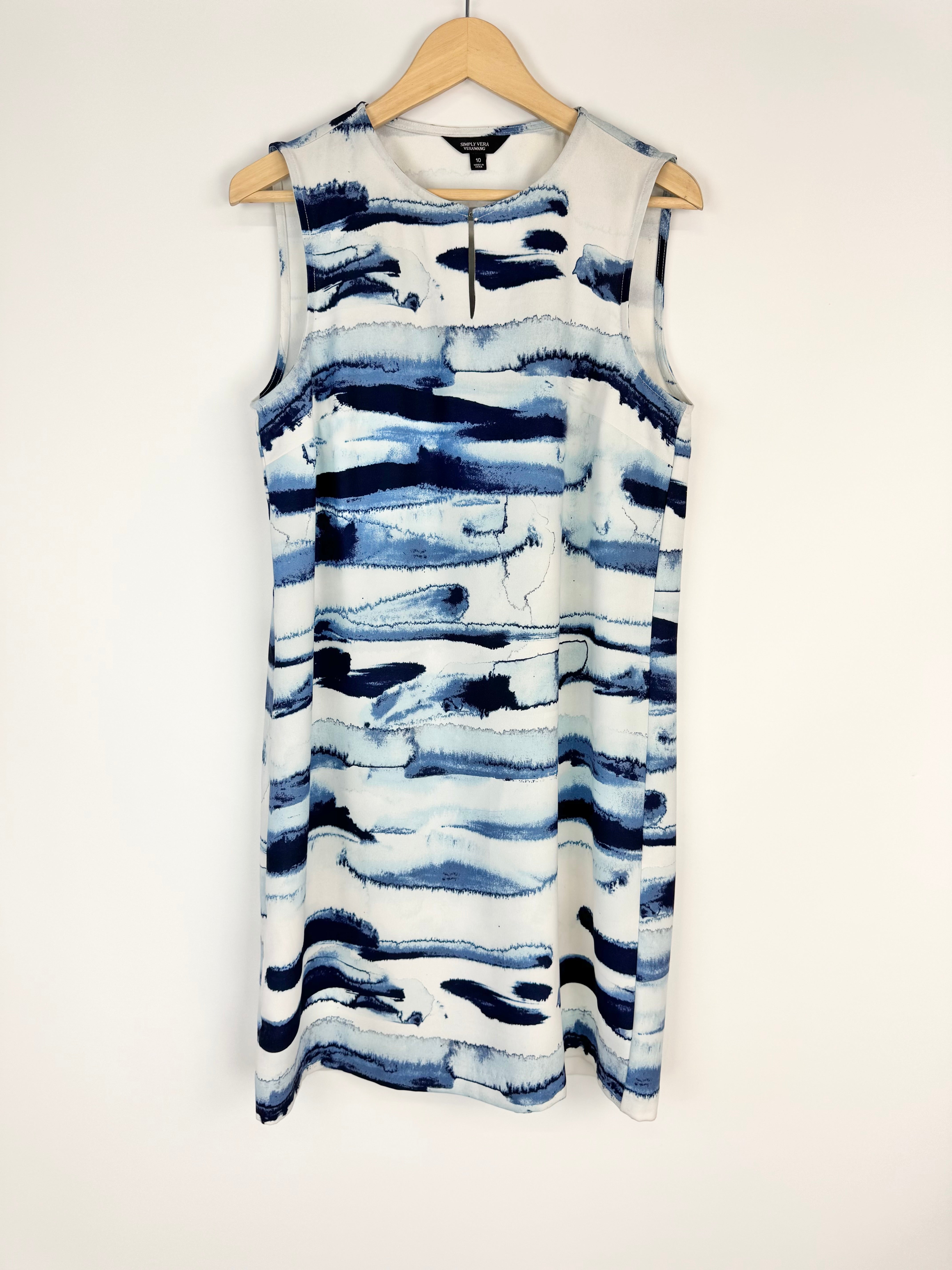 Blue and white sleeveless dress on a hanger against a white background