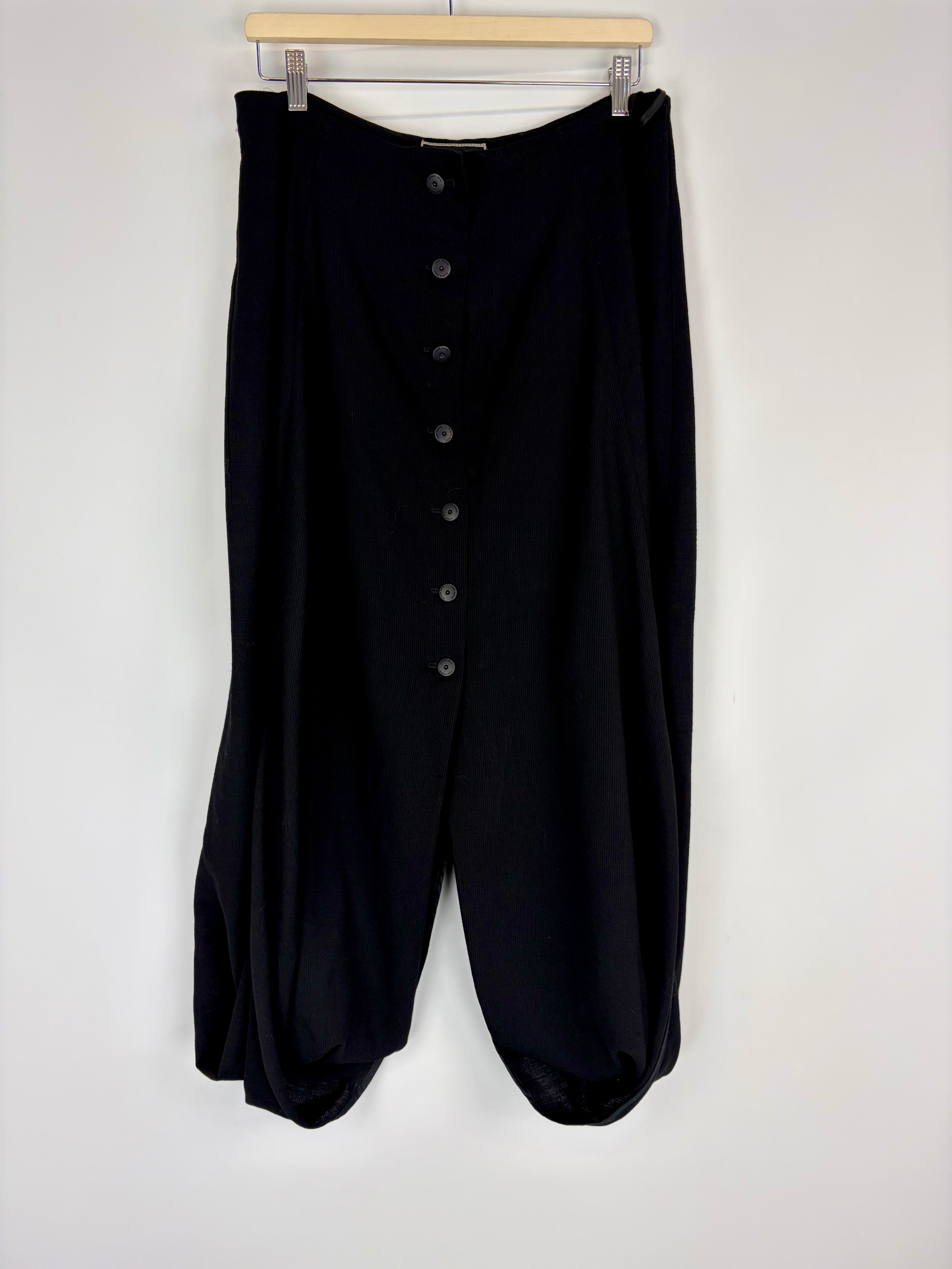 Black pants with button details on a white background