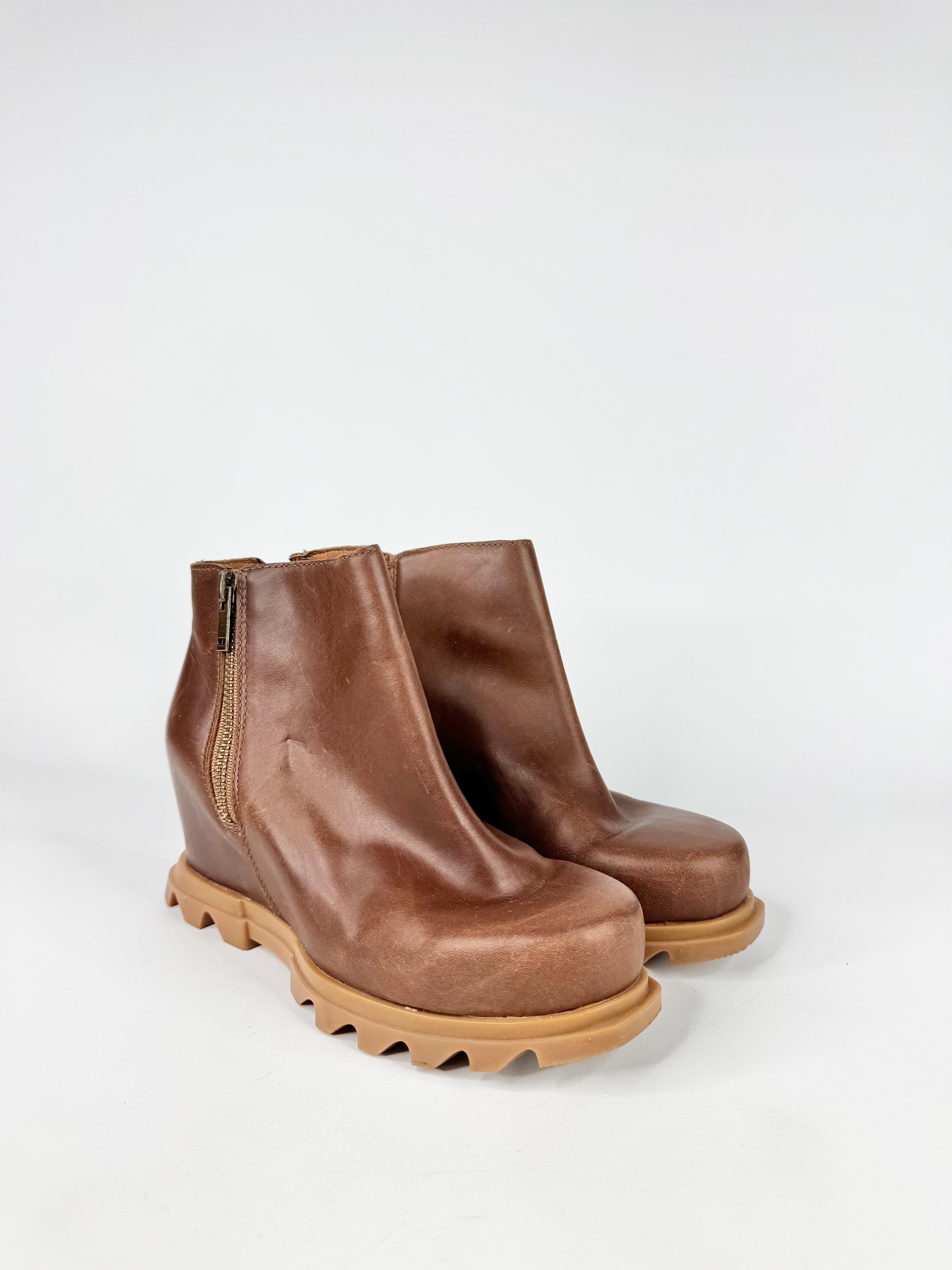 Pair of brown leather ankle boots on a white background