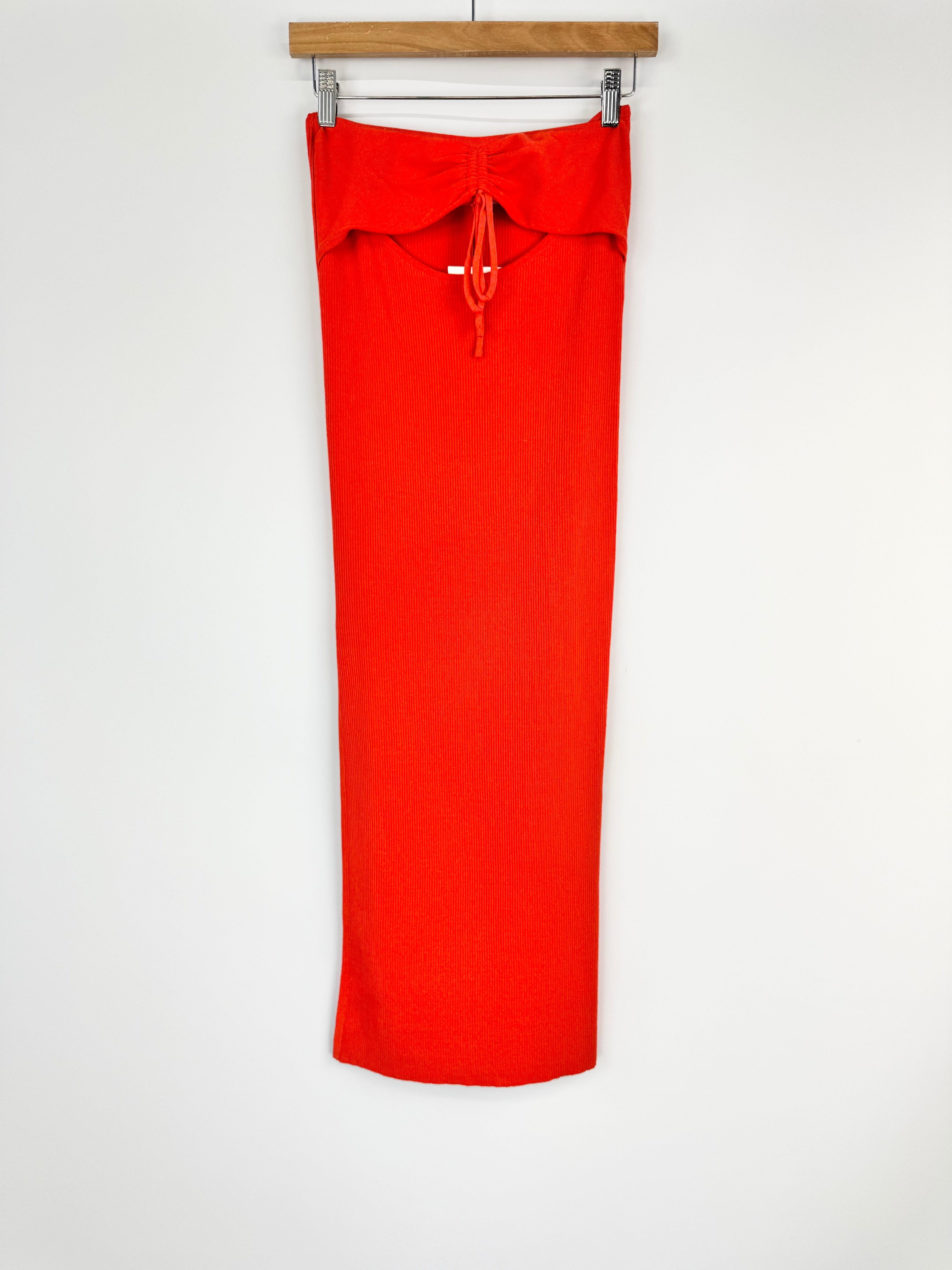 Orange skirt on a hanger against a white background