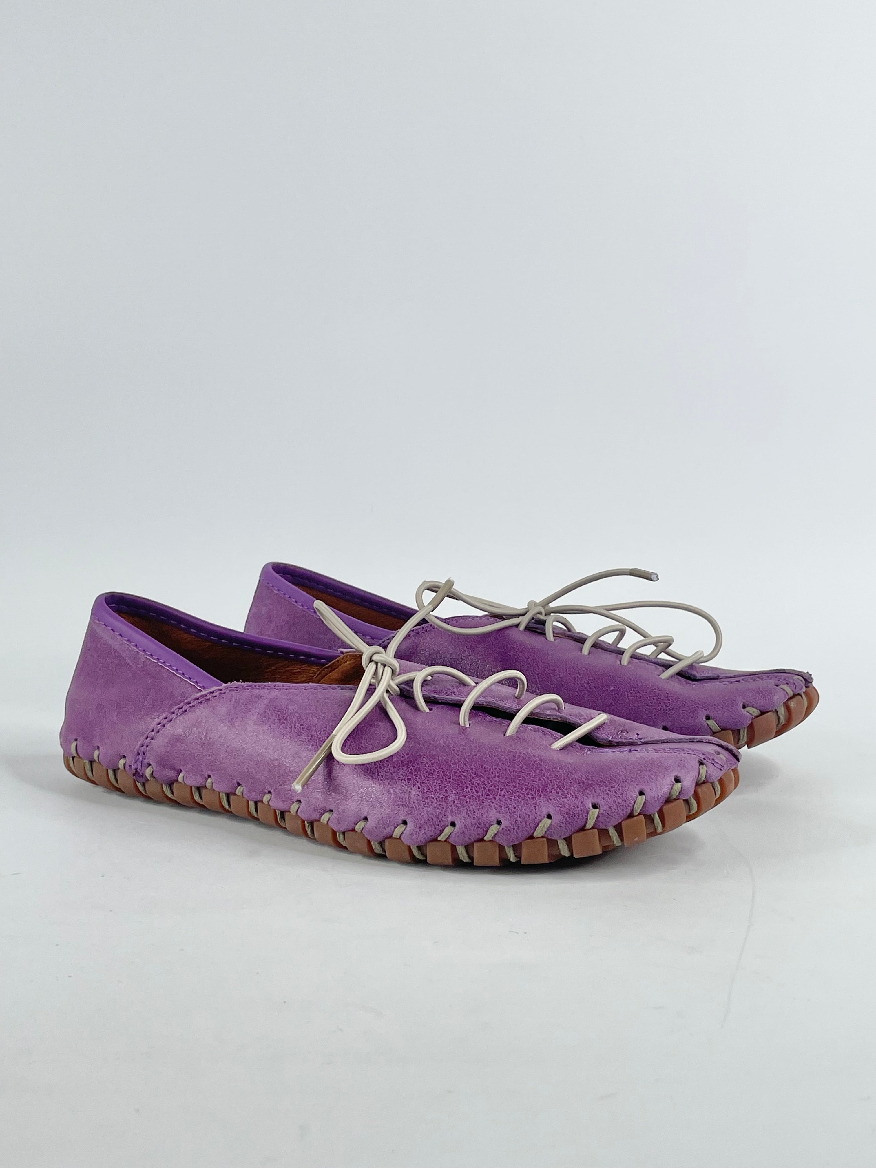 A pair of purple leather flat lace ups with a rubber sole, displayed against a white background.