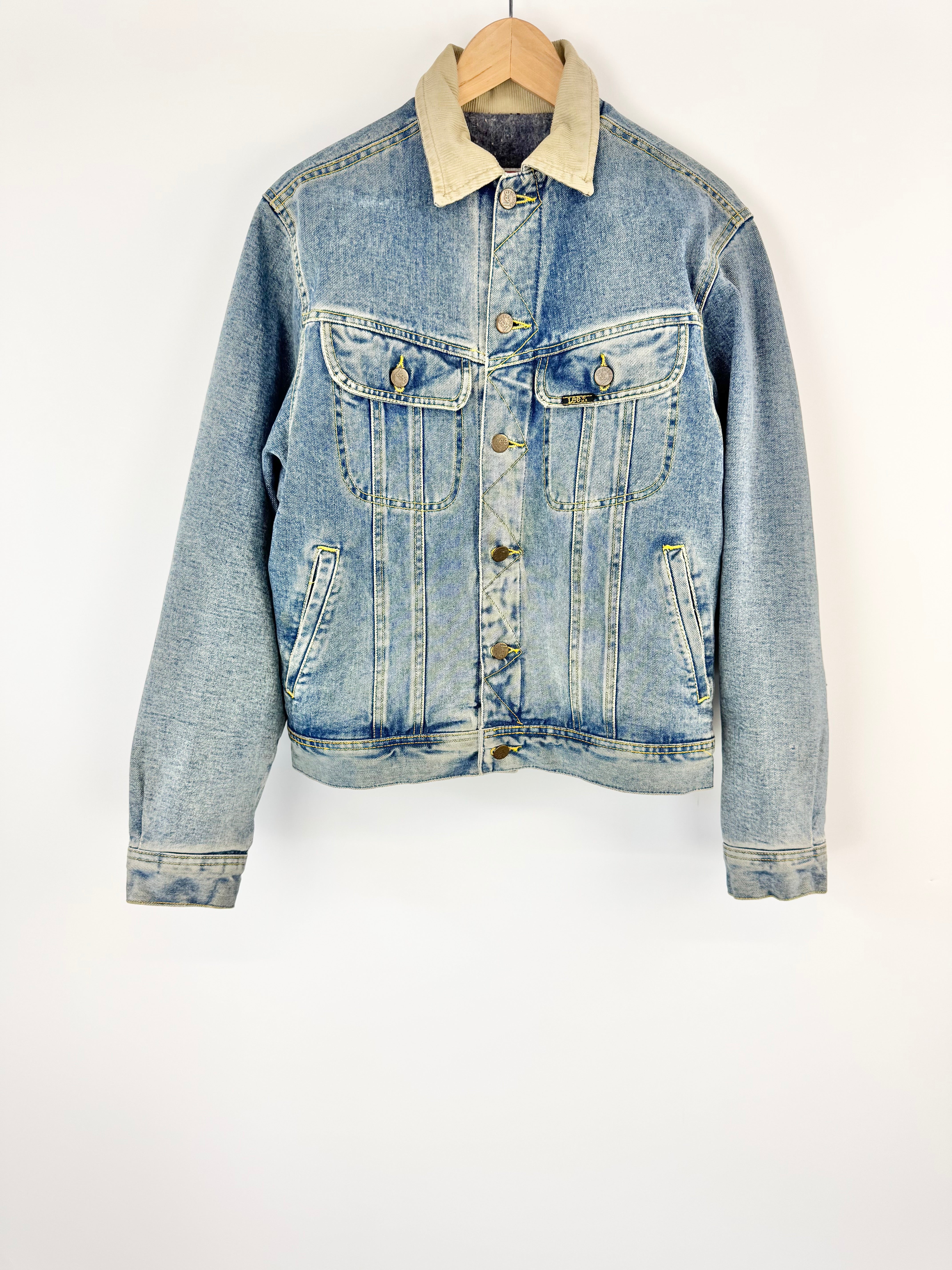 Blue denim jacket with a cream collar on a white background
