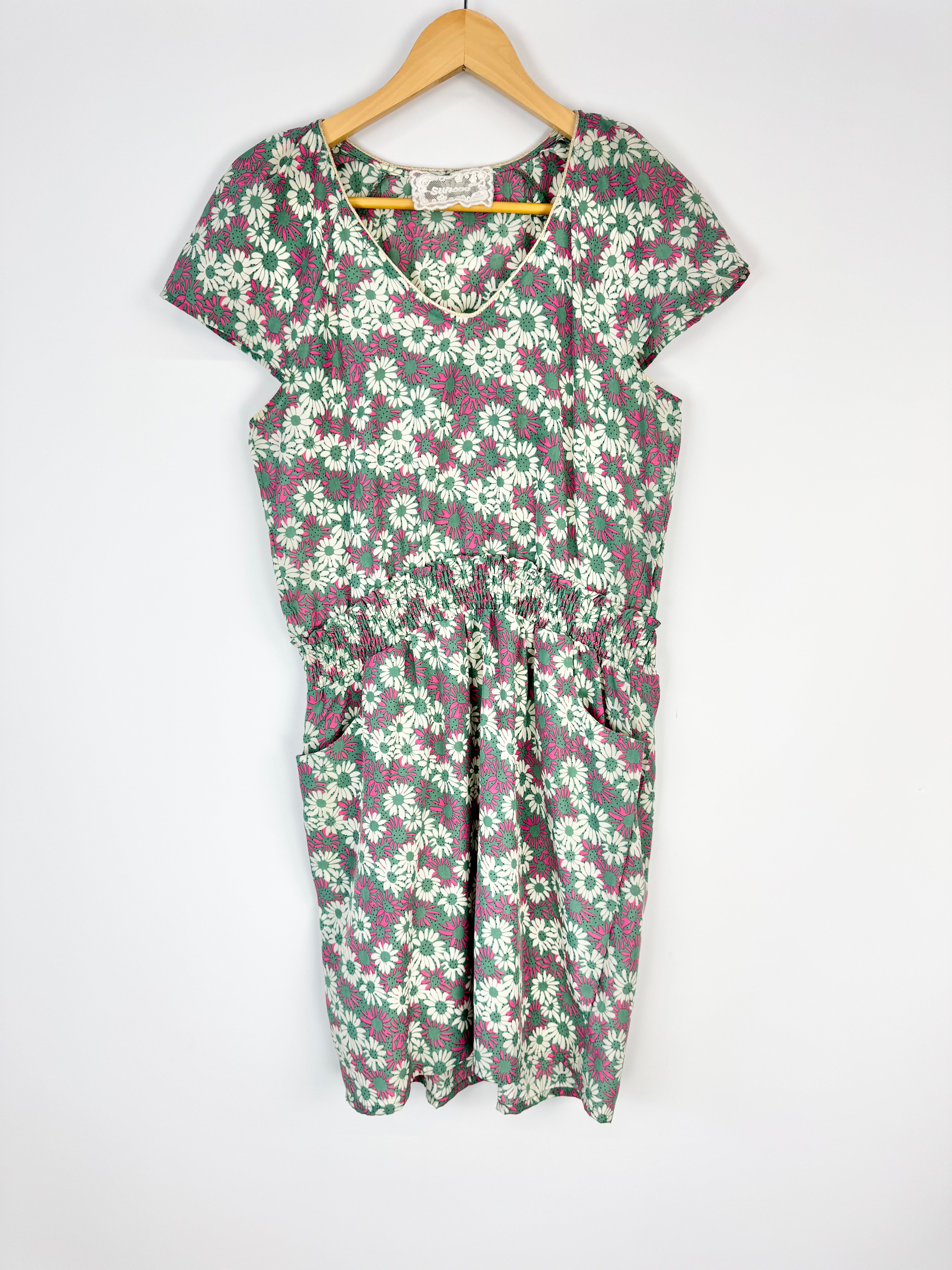 Floral dress on a hanger against a white background