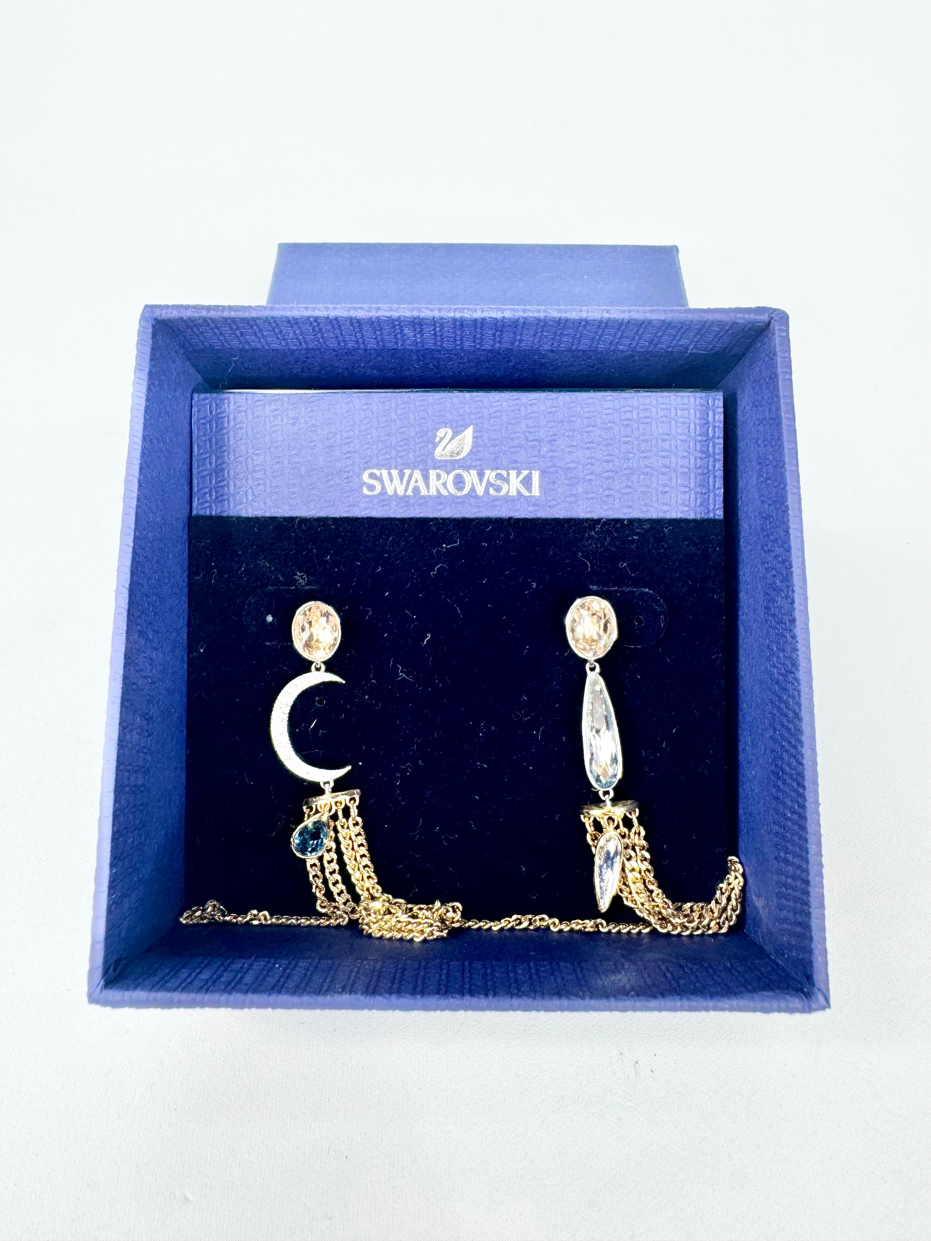 Swarovski earrings in a blue box on a white background