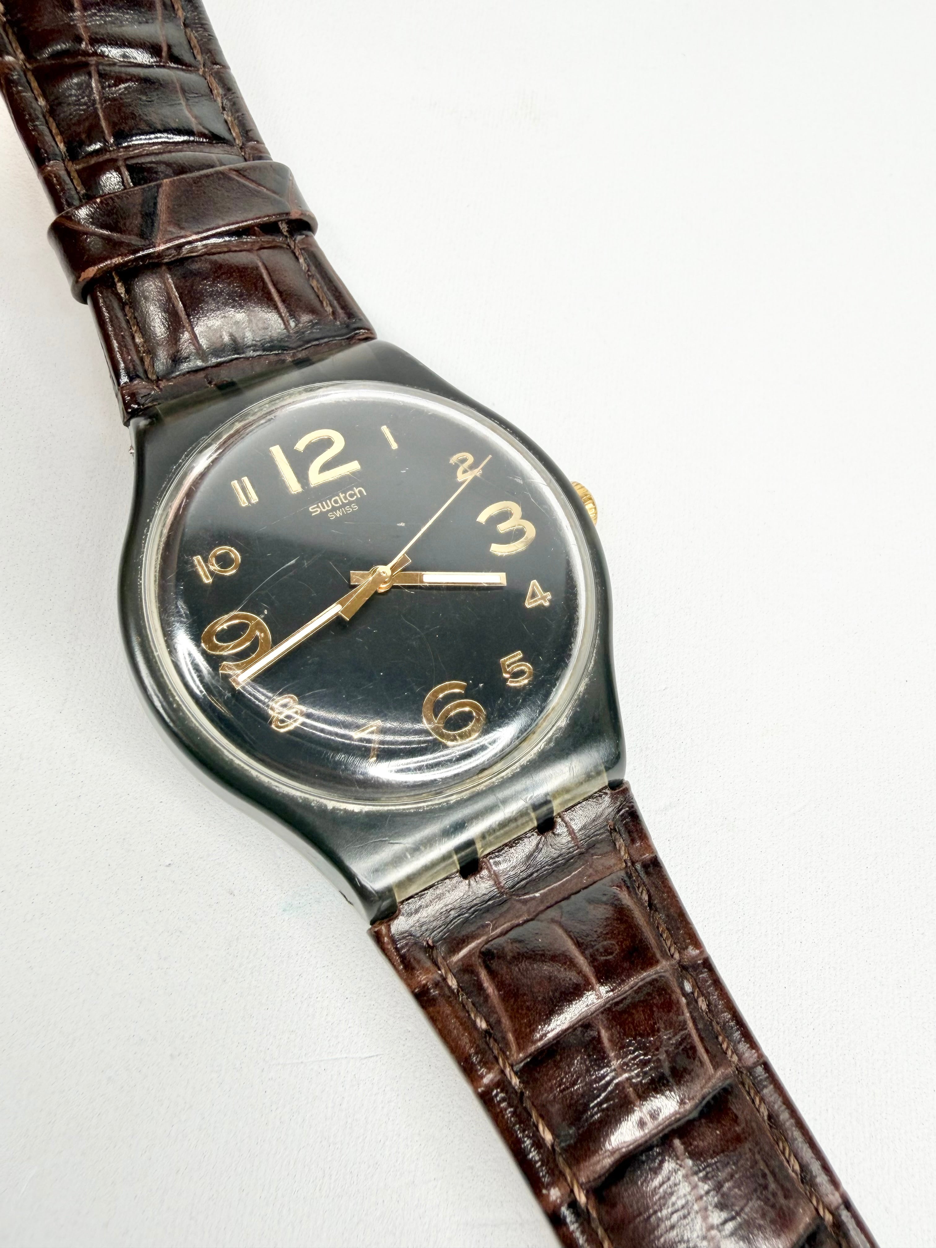 Vintage Swatch watch with brown leather strap on a white background