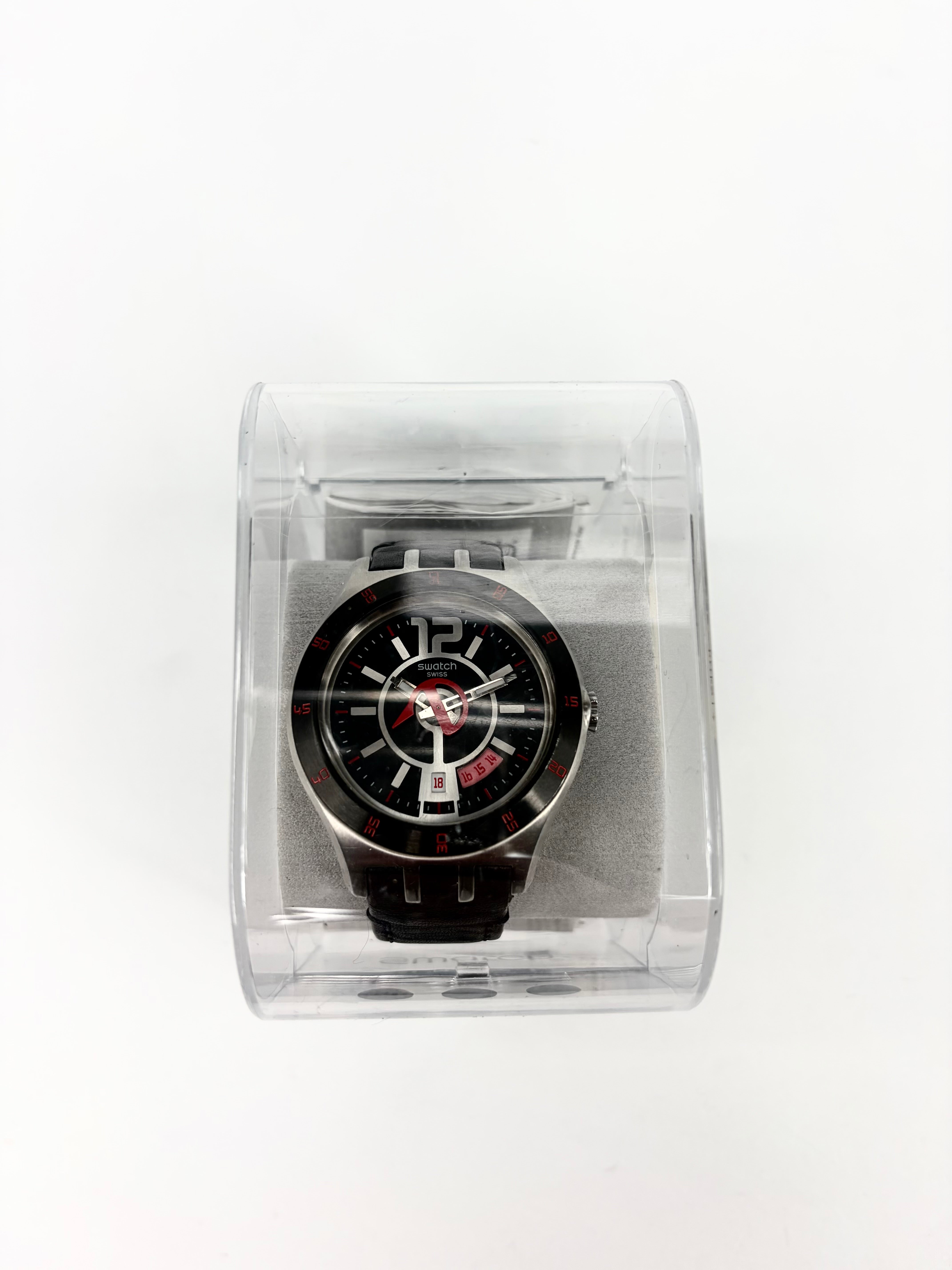 Black watch in a clear plastic box on a white background