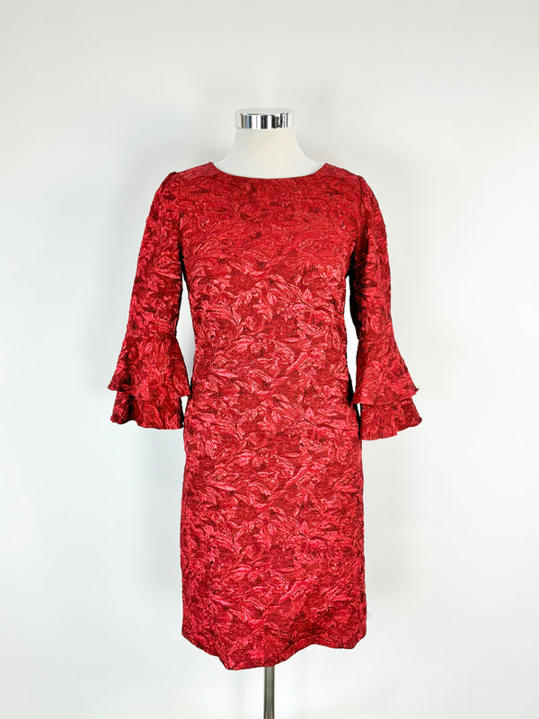 A ruby red, V-neck, sleeveless, midi dress with metallic thread detailing, displayed on a mannequin.