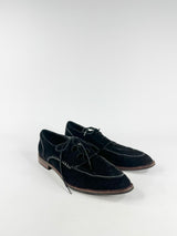 Pair of black suede shoes on a white background