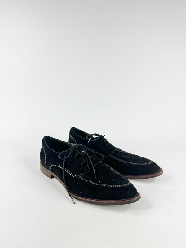 Pair of black suede shoes on a white background