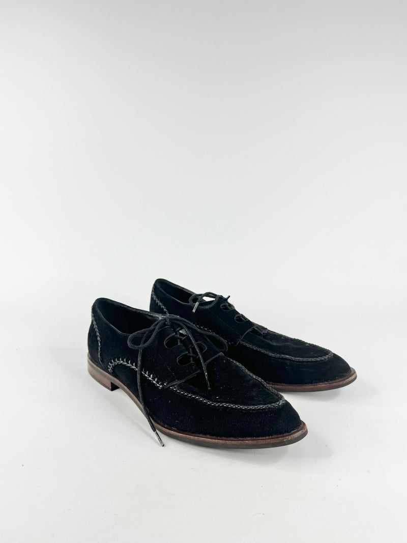 Pair of black suede shoes on a white background