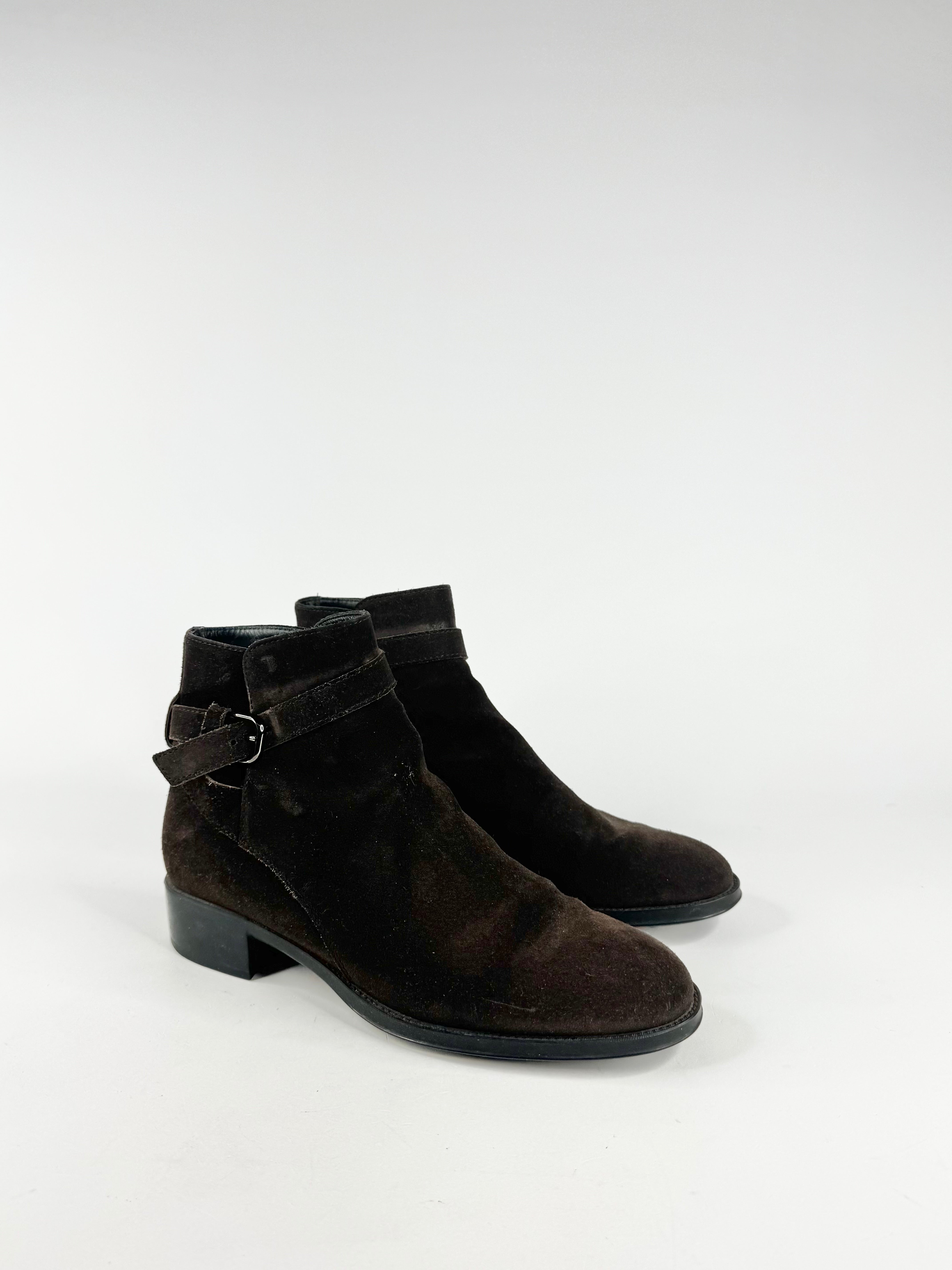 Pair of mahogany suede ankle boots with buckles on a white background
