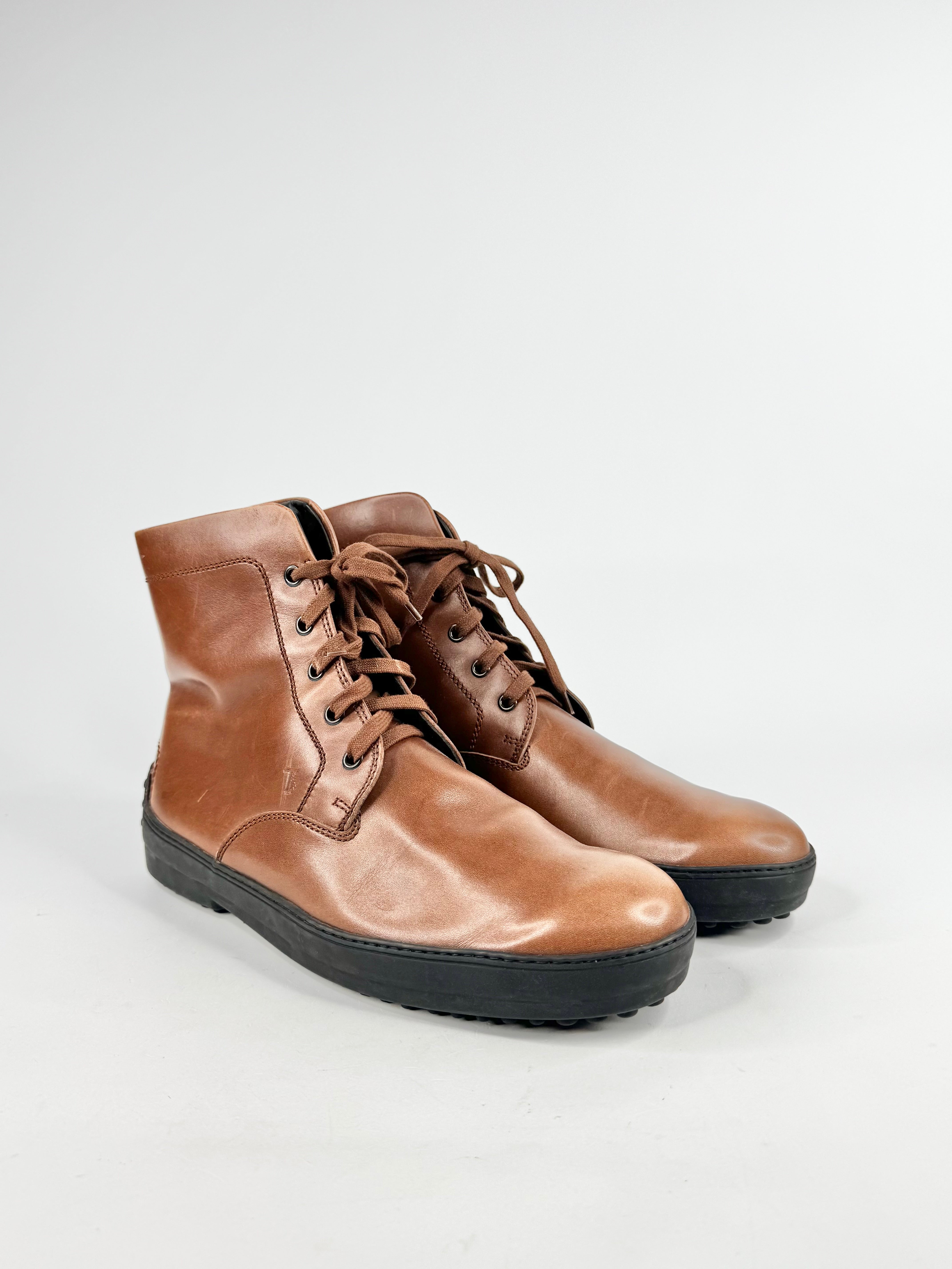 Pair of tan lace up boots on a white background