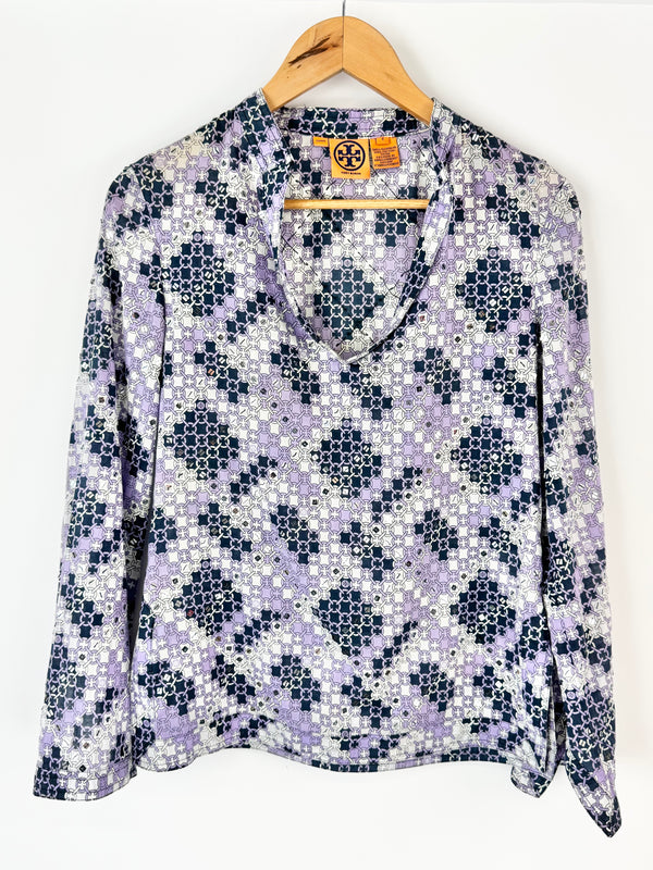 Floral patterned blouse on a hanger against a white background