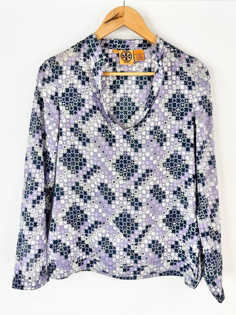 Floral patterned blouse on a hanger against a white background