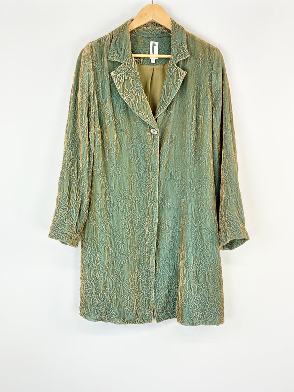 Green textured jacket on a hanger against a white background