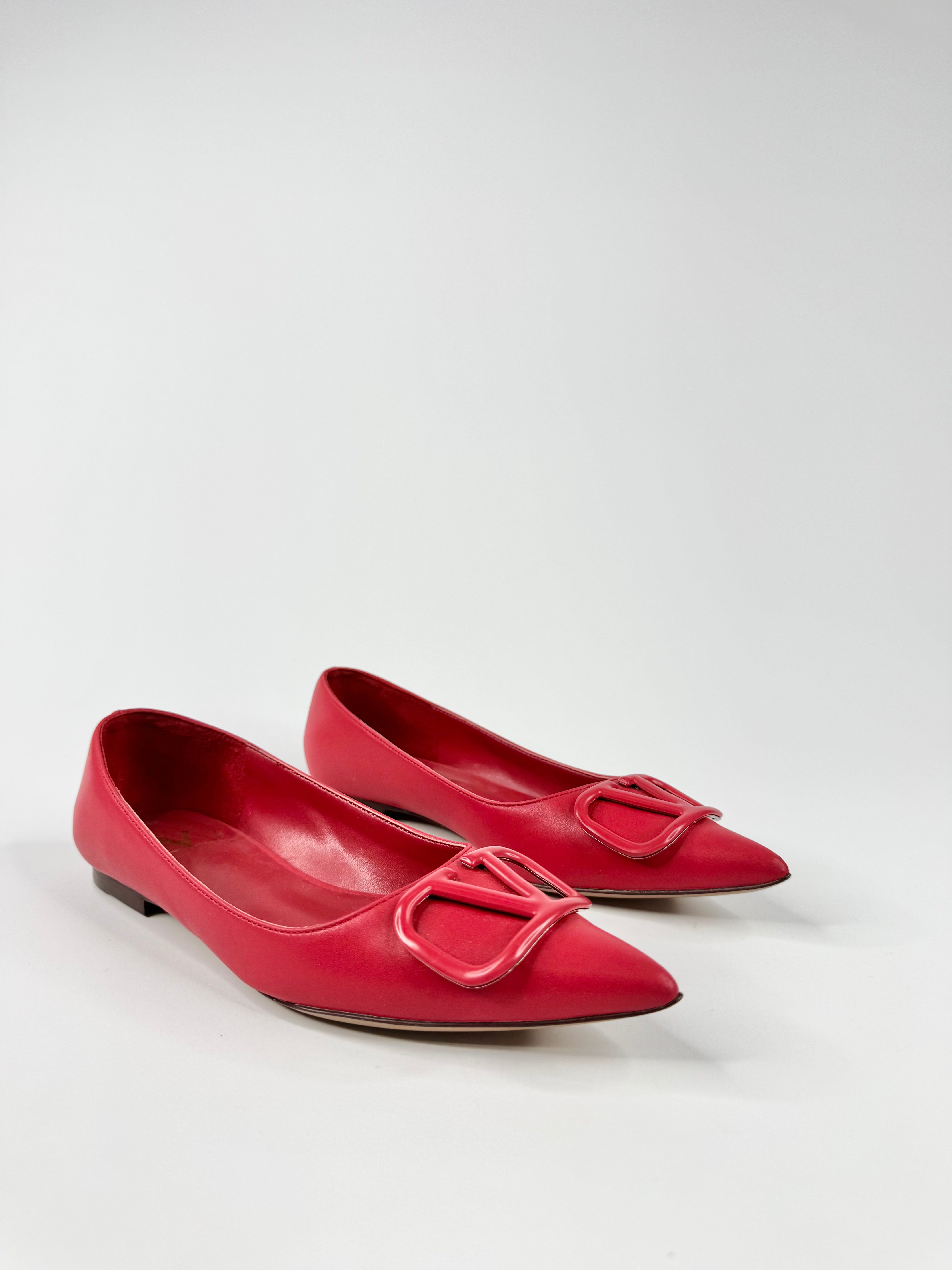 Pair of red shoes with a decorative buckle on a white background