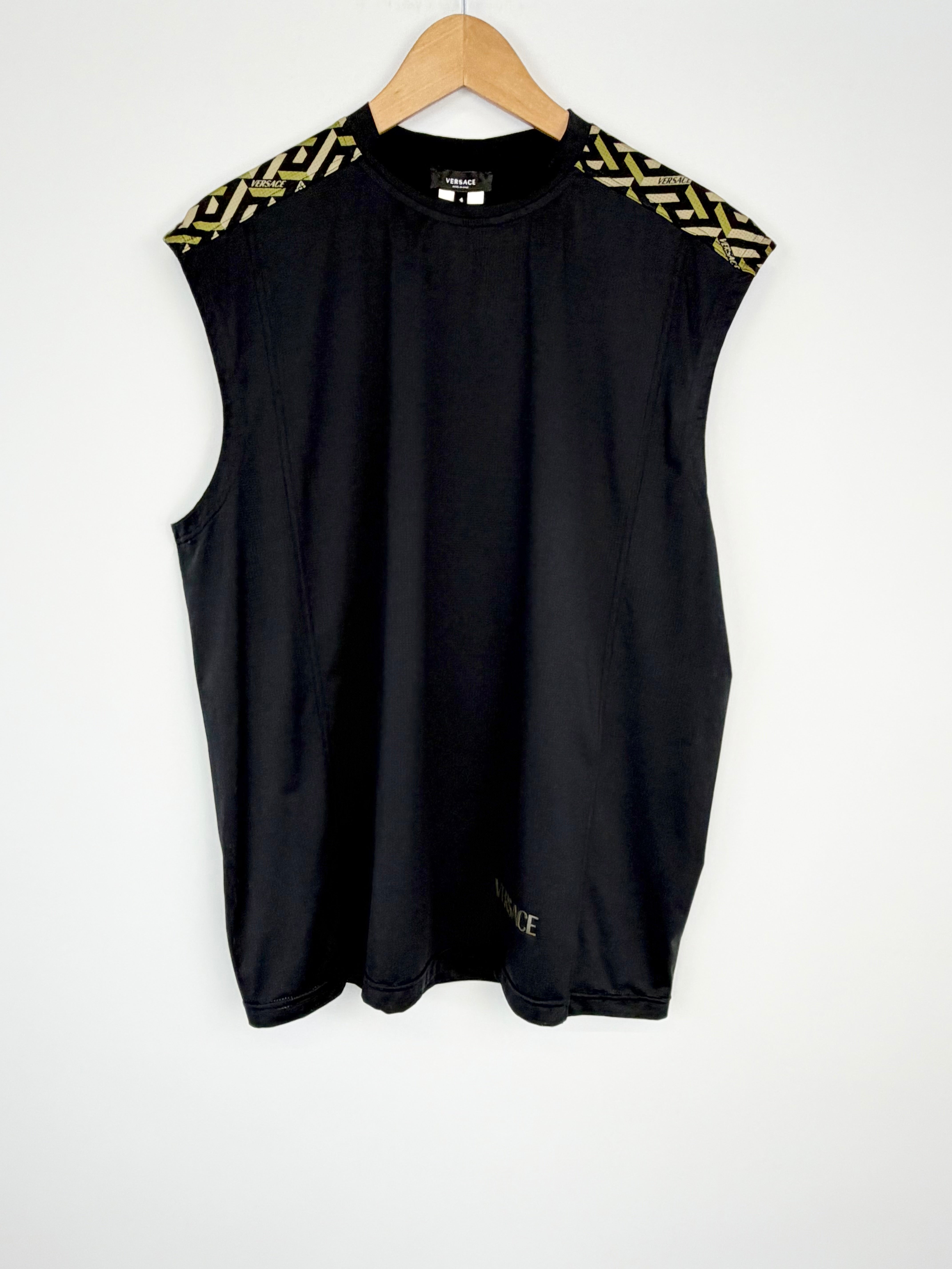 Black sleeveless top with gold accents on a hanger against a white background