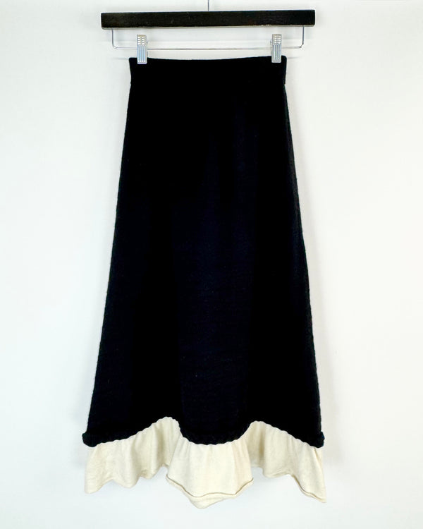 Black skirt with white ruffle hem on a white background